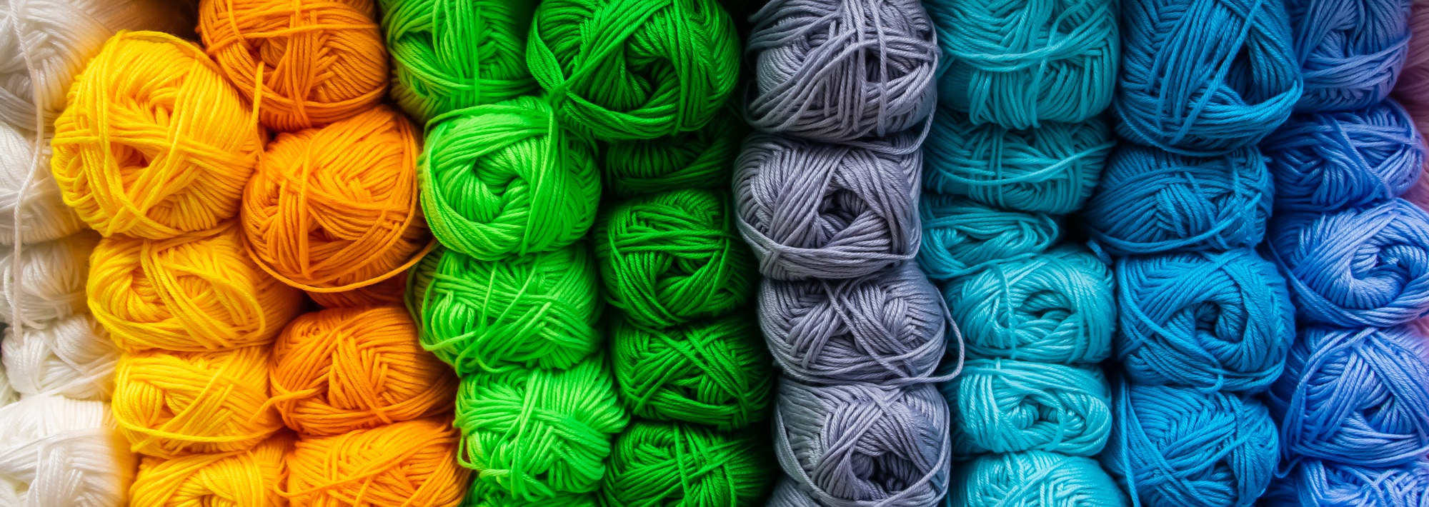 Many balls of wool yarn for knitting. Selling fluffy threads in a craft store