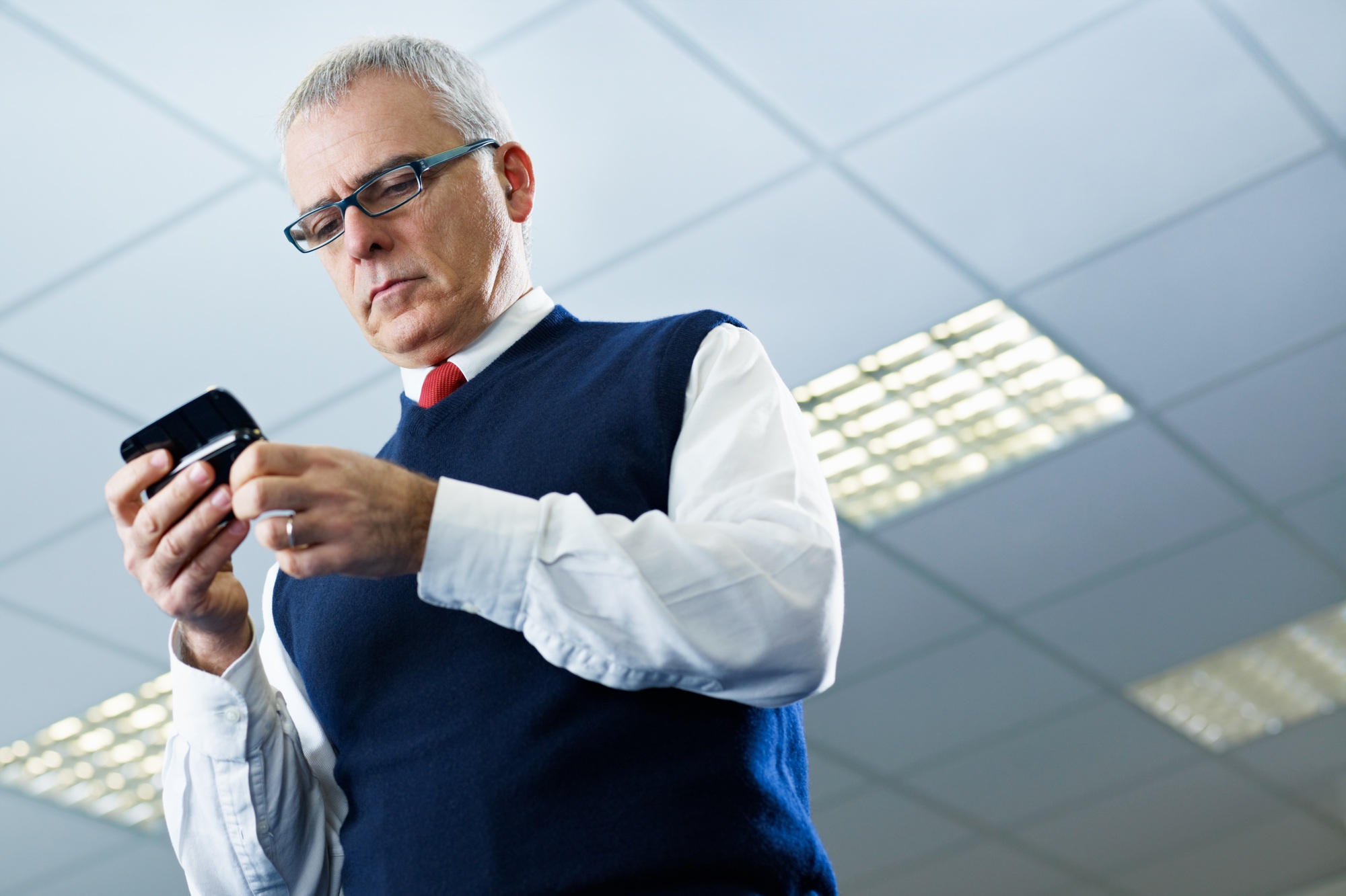 mature businessman reading e-mails on cellphone