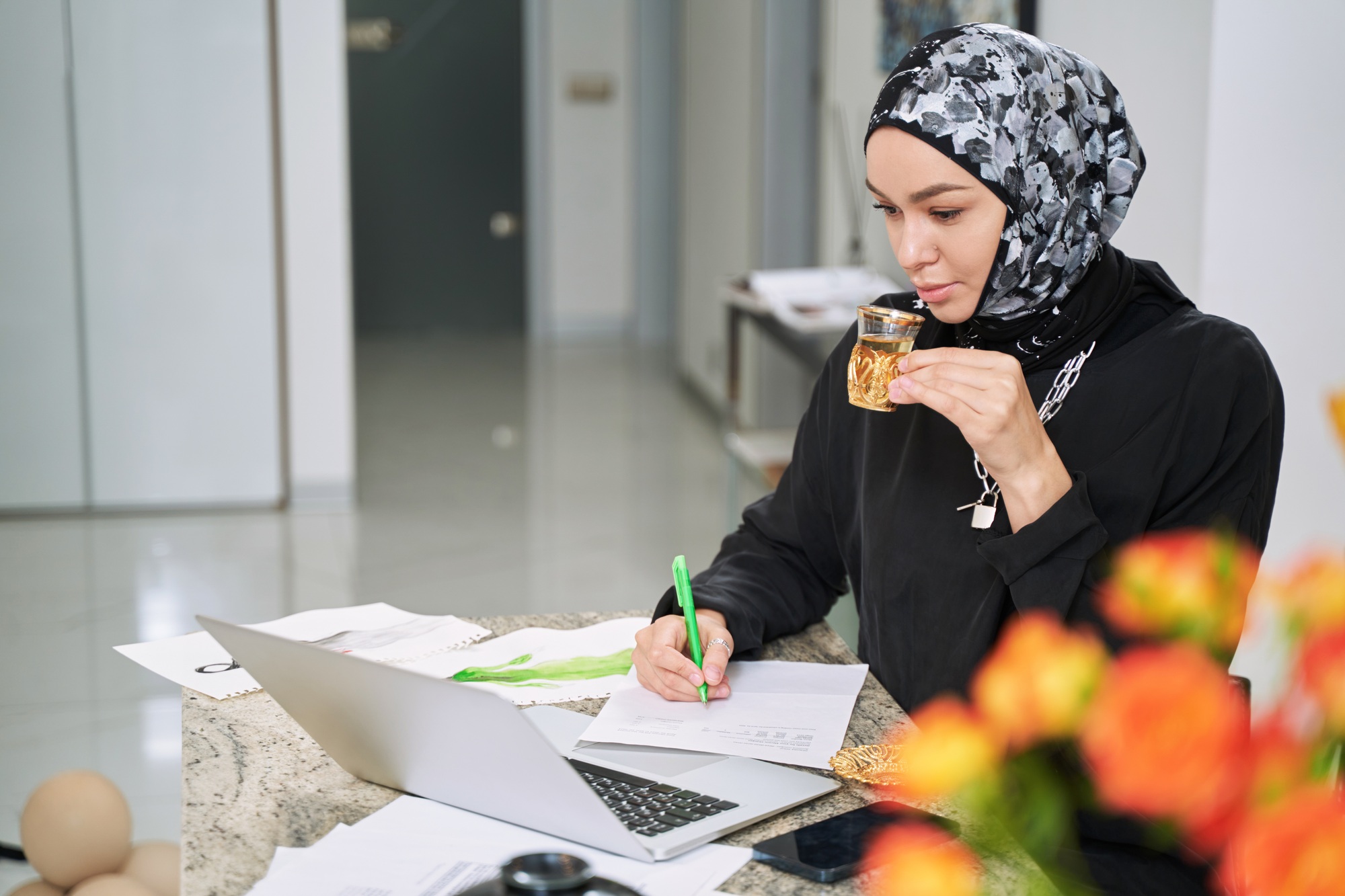 Muslim tea working online at home with cup of tea