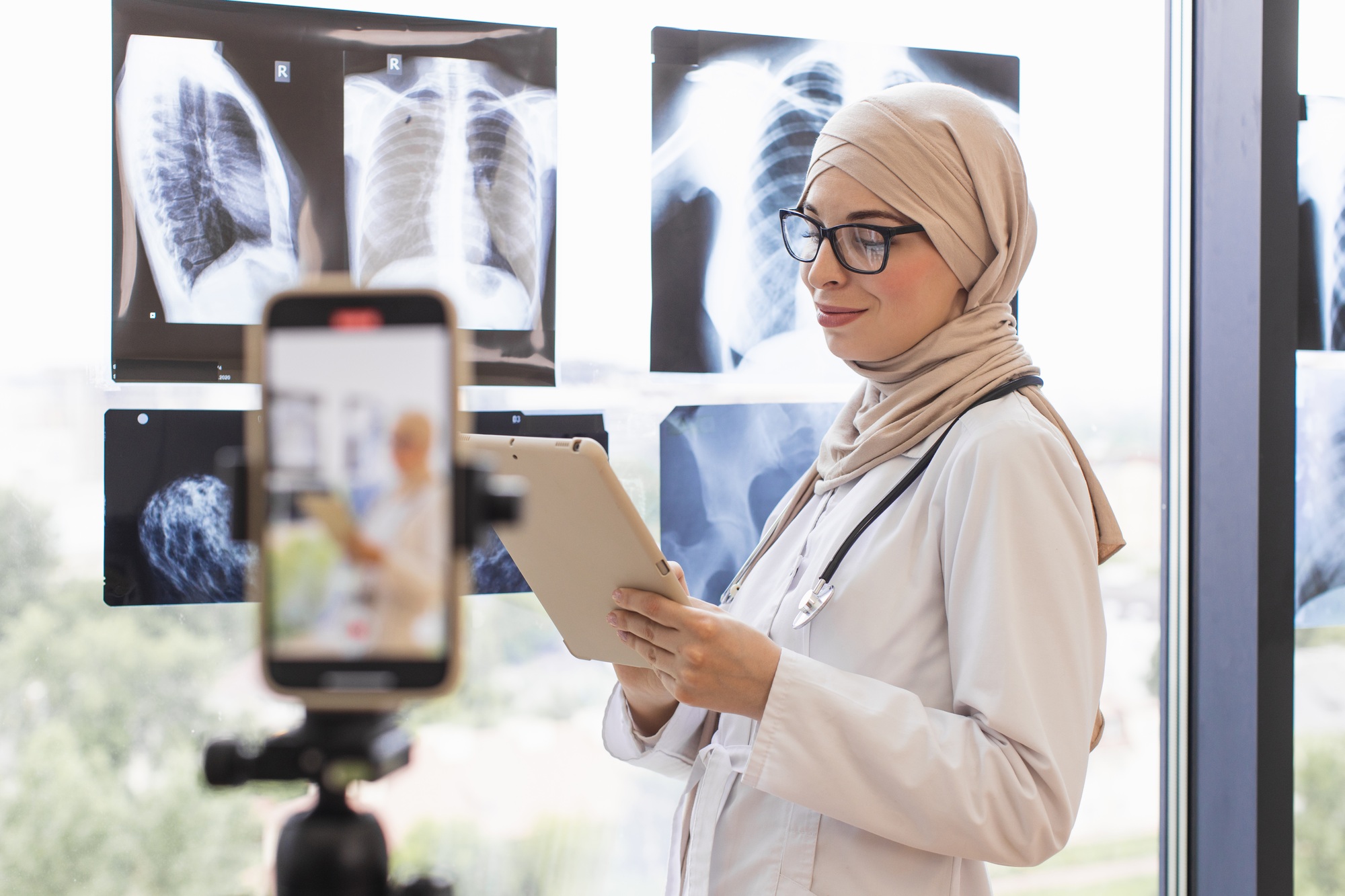 Muslim woman doctor recording video lesson using x-ray images