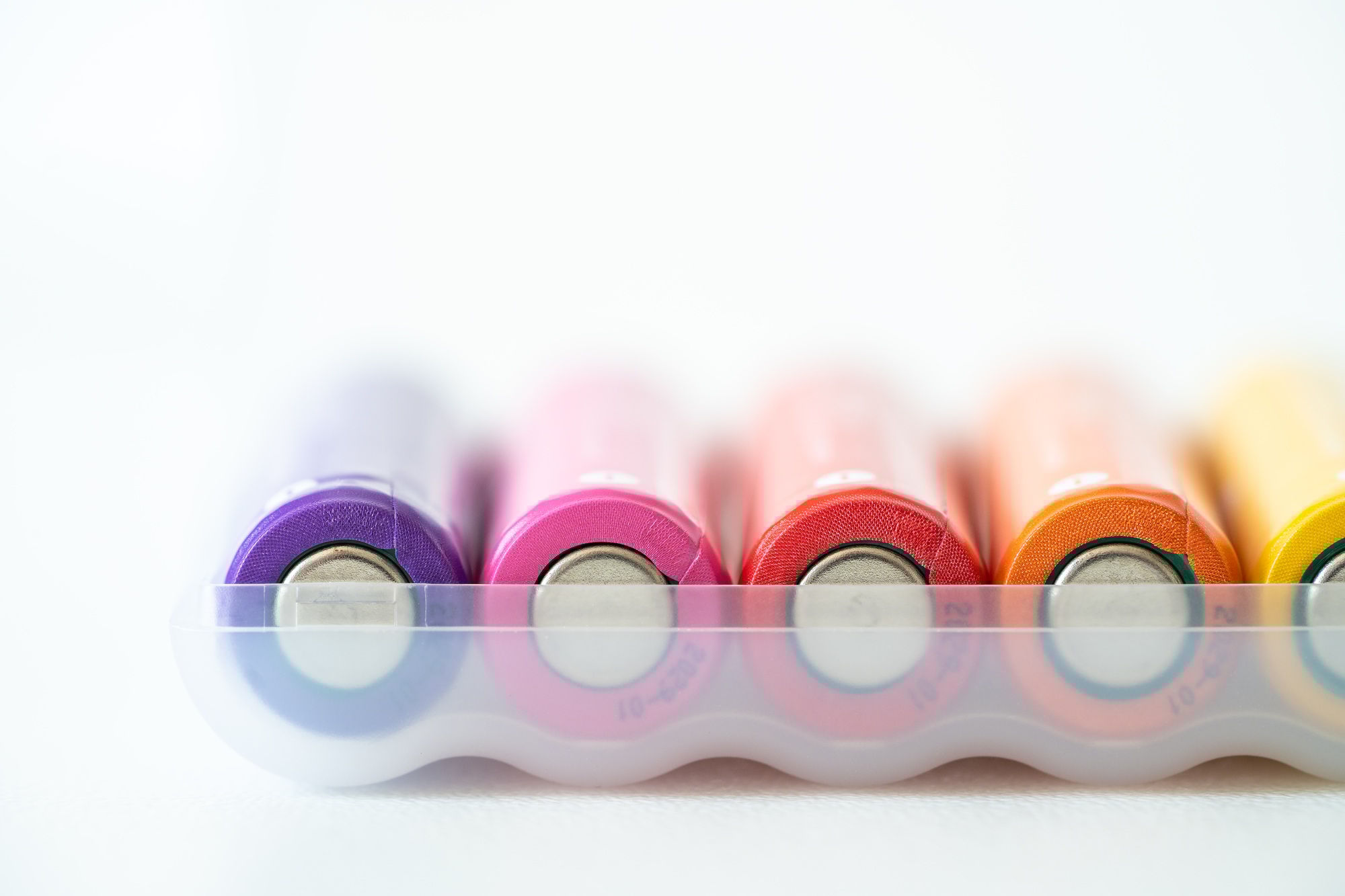 New colorful AAA battery in plastic box, rechargeable accumulator, closeup of alkaline batteries