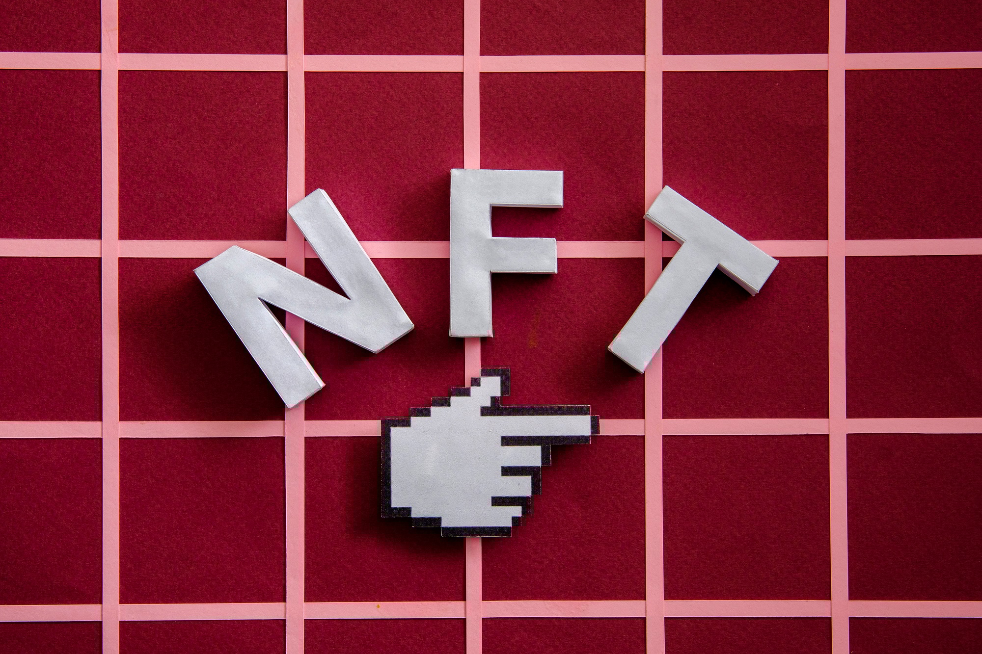 NFT and pixel finger mouse pointer on a red background