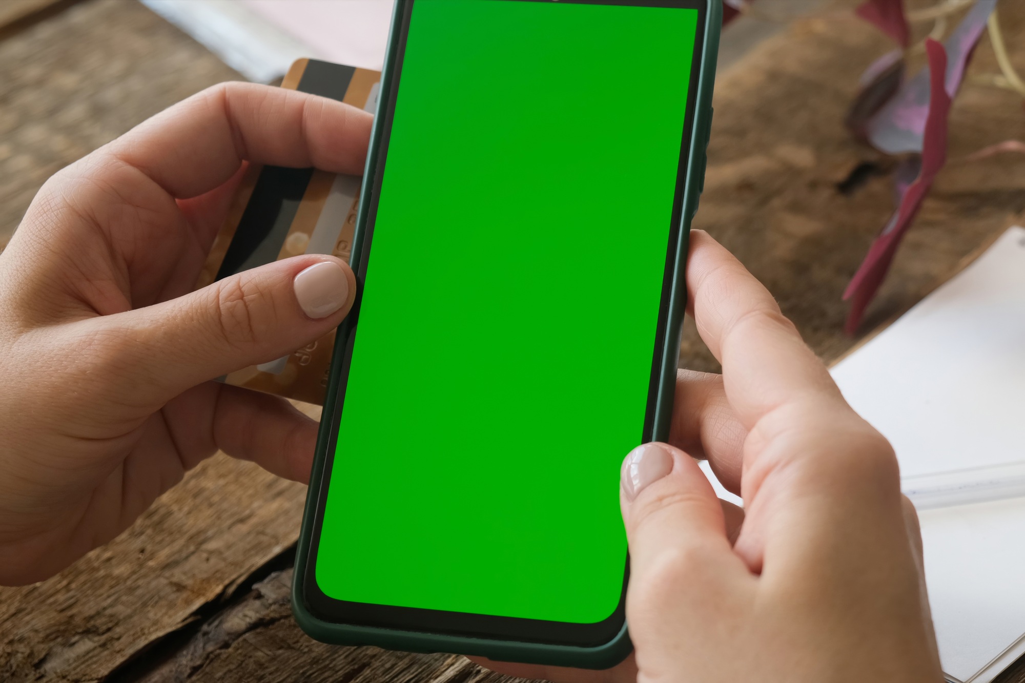 Online payments, mobile app mockup. Hands holding phone with green screen.