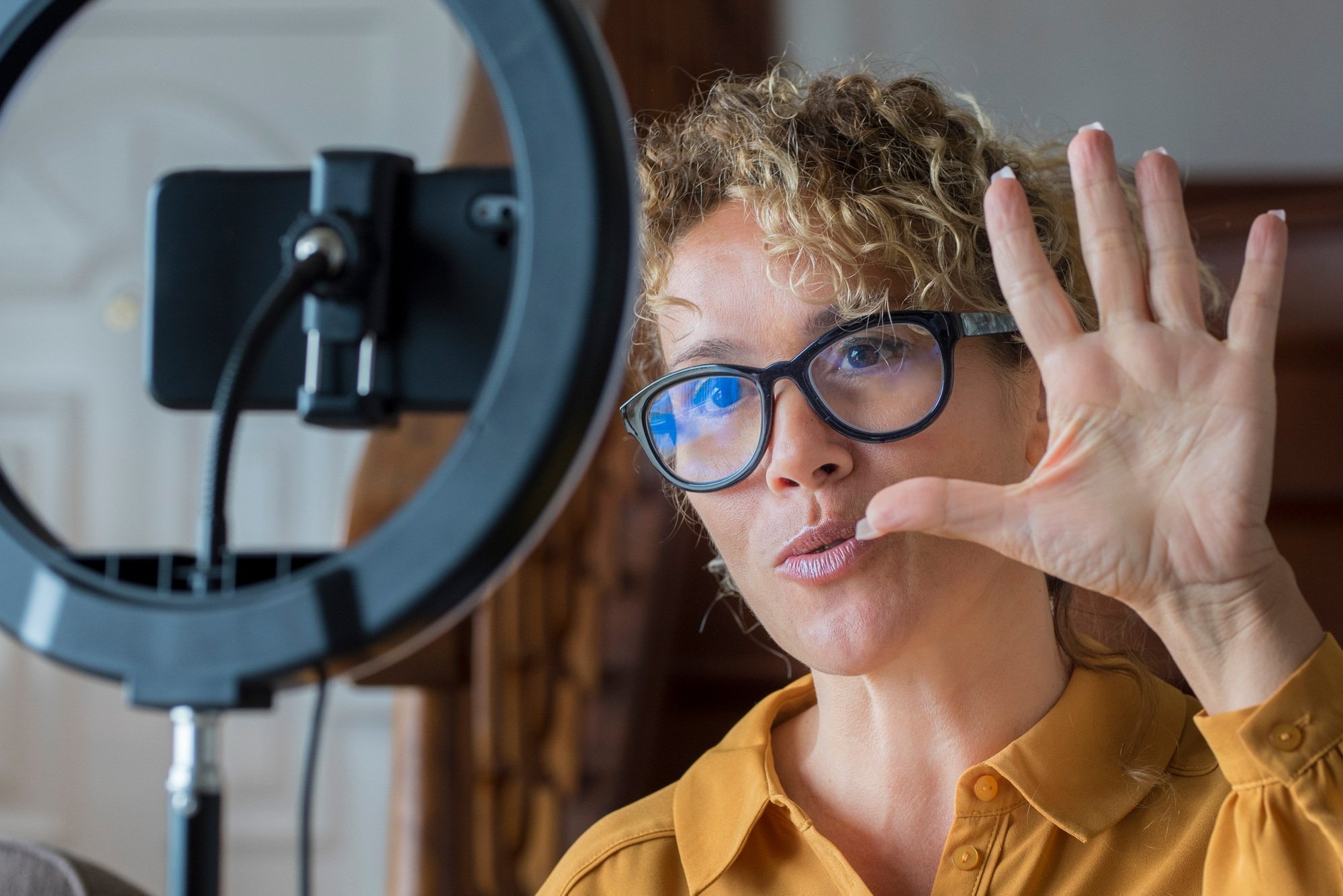 People in content creating activity. Modern woman working at home with mobile phone
