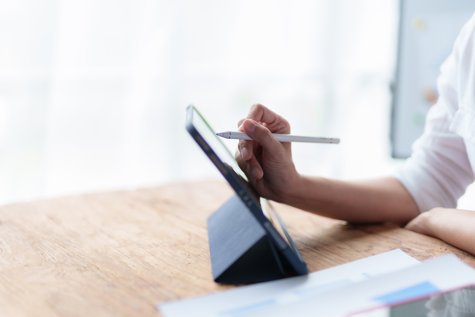 Person using stylus on digital tablet for creative project. Technology and digital art concept.