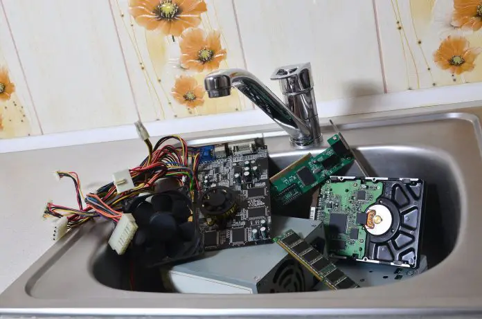 Personal computer cleaning metaphoric concept. Hardware in kitchen sink
