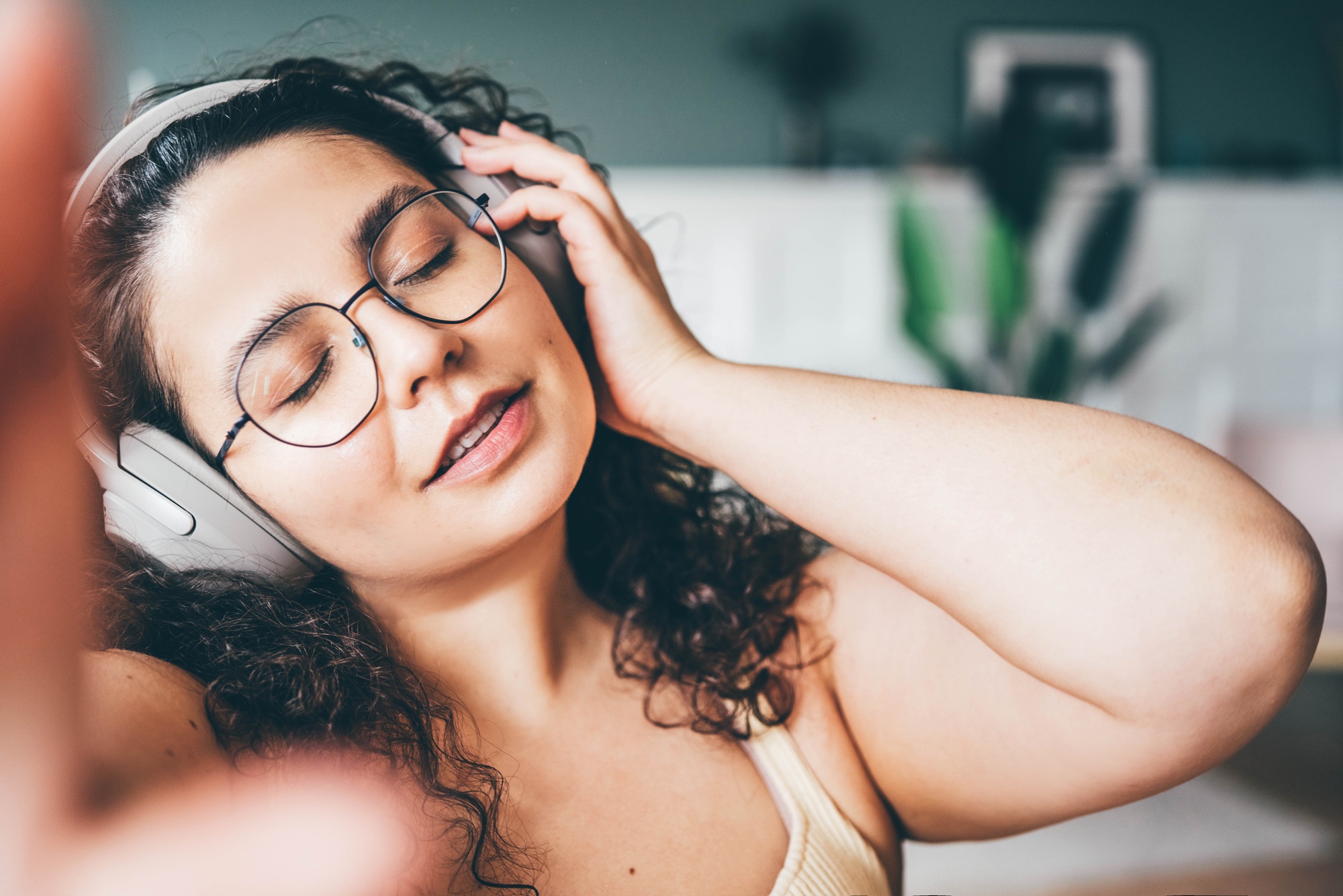 plus size young woman blogger in wireless headphones makes video on phone camer