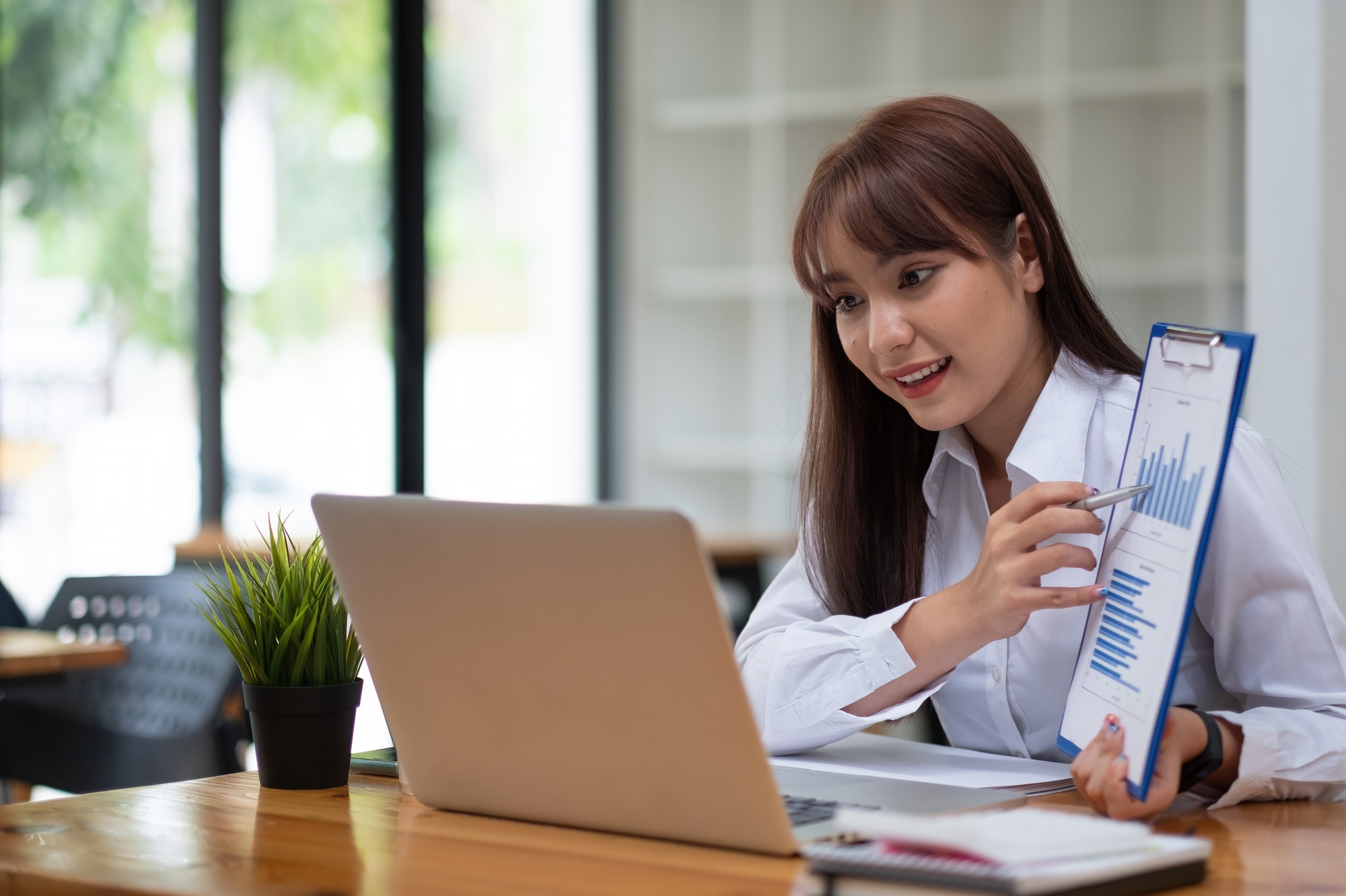 Portrait of attractive business female showing customer engagement graph report on online meeting