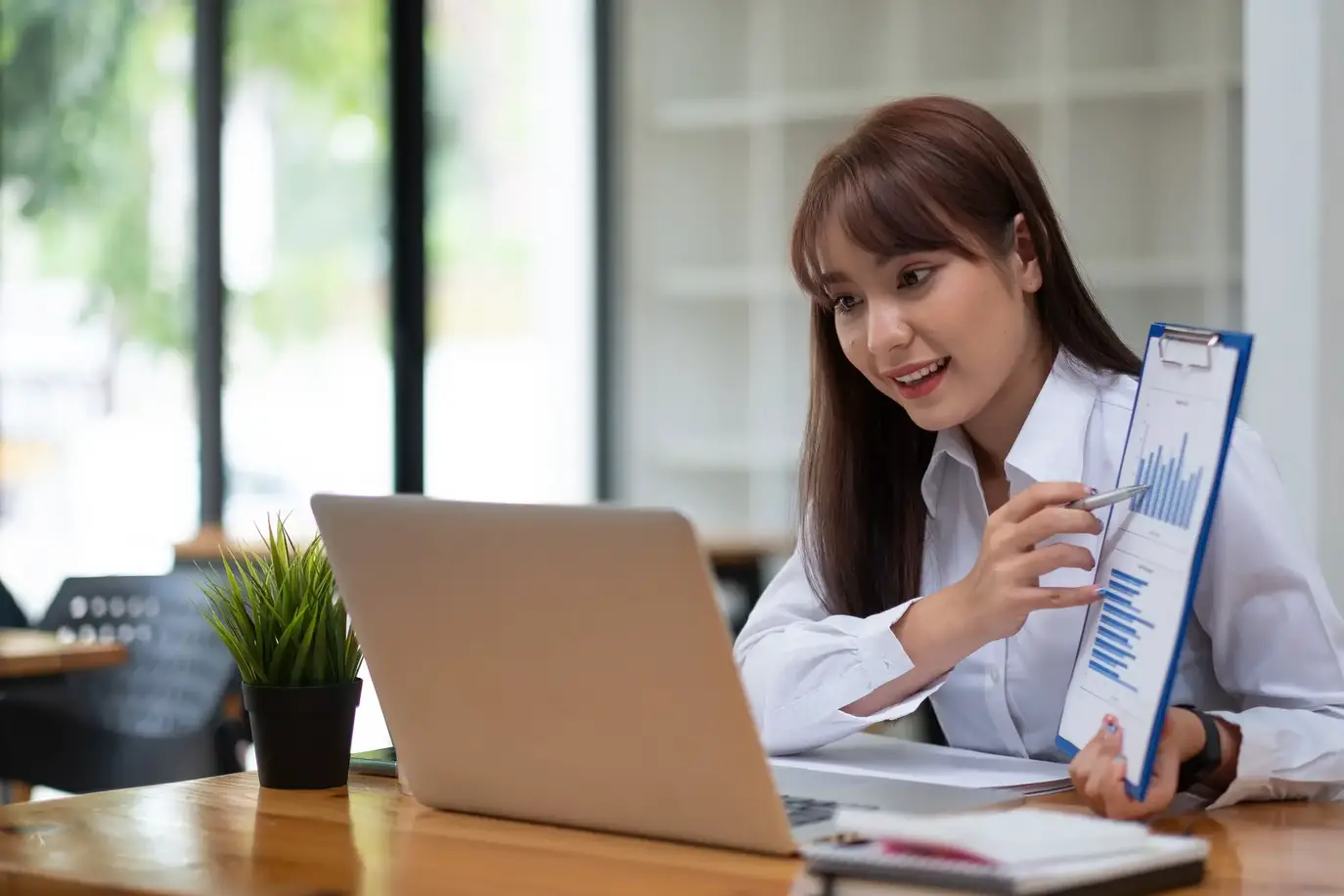 Portrait of attractive business female showing customer engagement graph report on online meeting