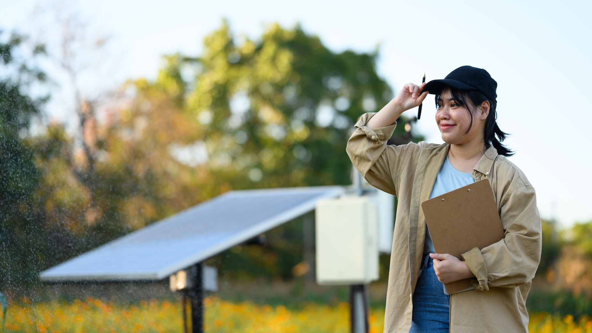 Portrait of farmer woman standing in front of solar panels on farm.