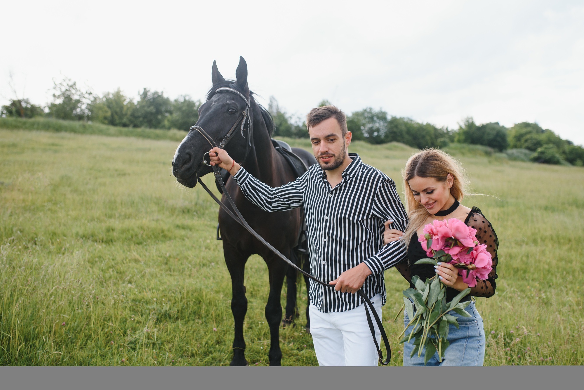 Portrait of happy loving couple spending time with horses on ranch