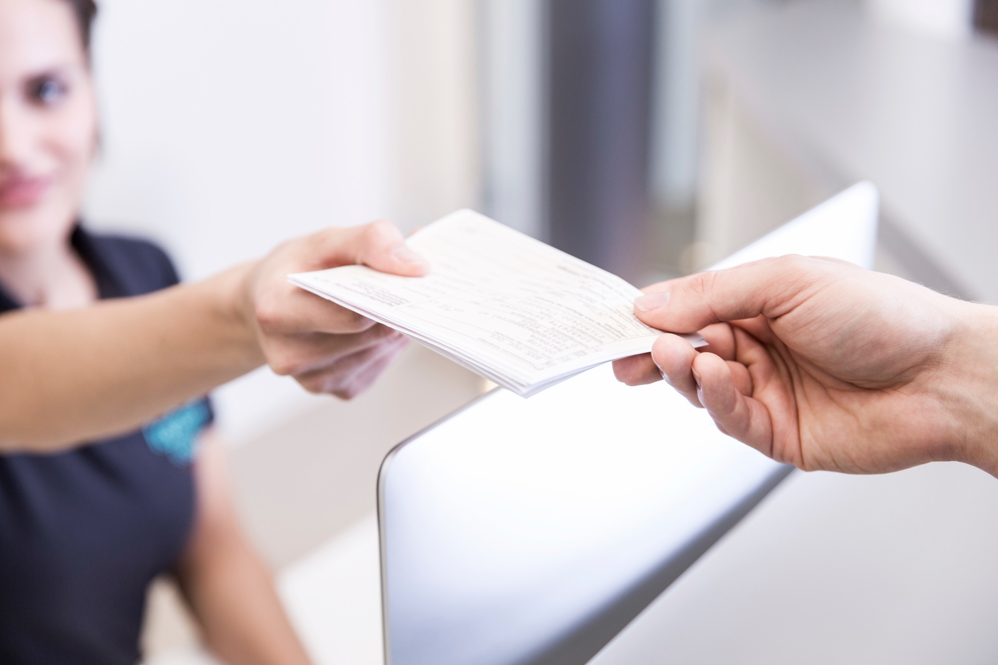 Receptionist handing prescription to patient