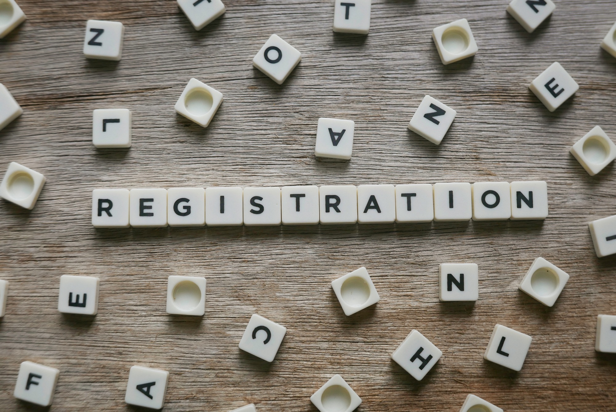 Registration word made of square letter word on wooden background.