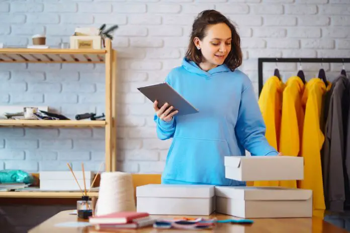 Small business owner, entrepreneur, seller using tablet checking ecommerce clothing store orders.