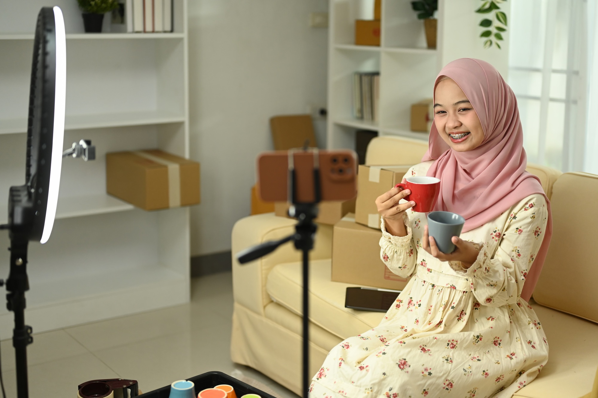 Smiling small business owne presenting ceramics products to her audience. E-commerce concept