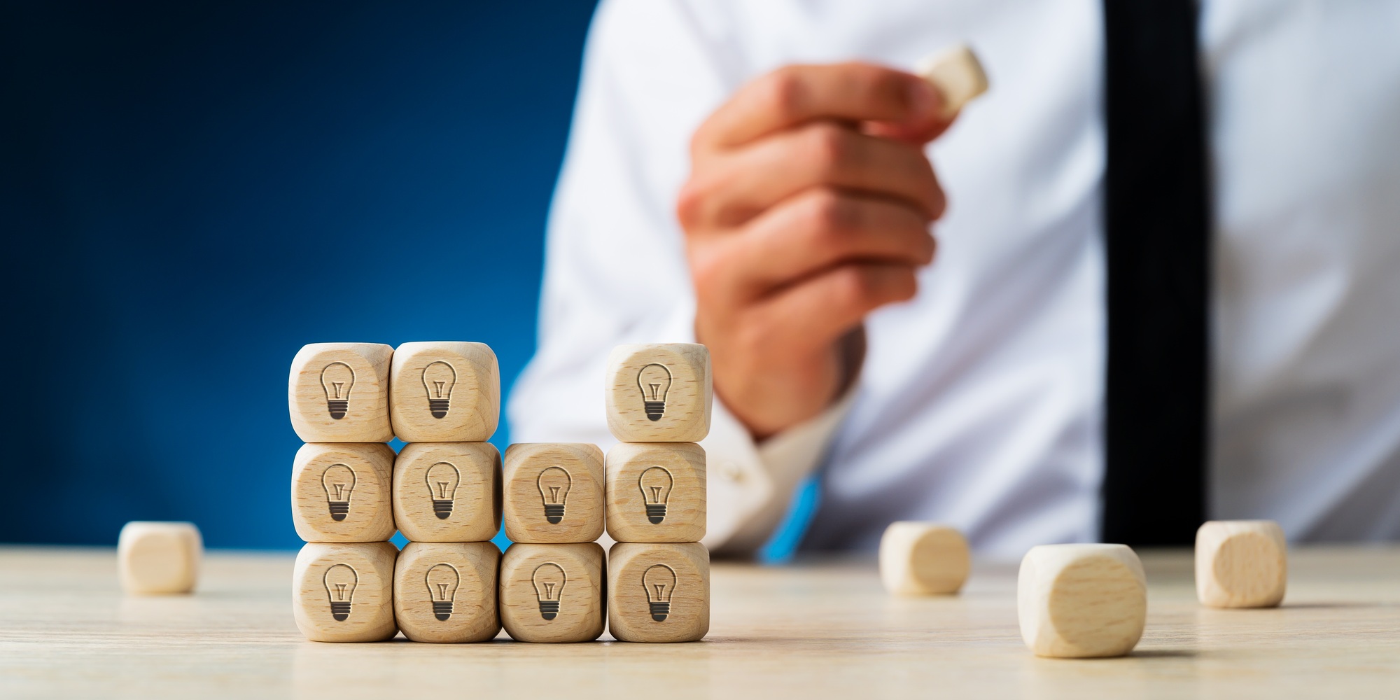 Stack of wooden dices with light bulb symbol