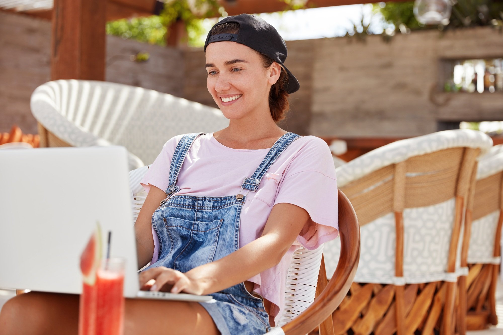 Stylish blue eyed beautiful female freelancer checks email on laptop computer, uses application on m