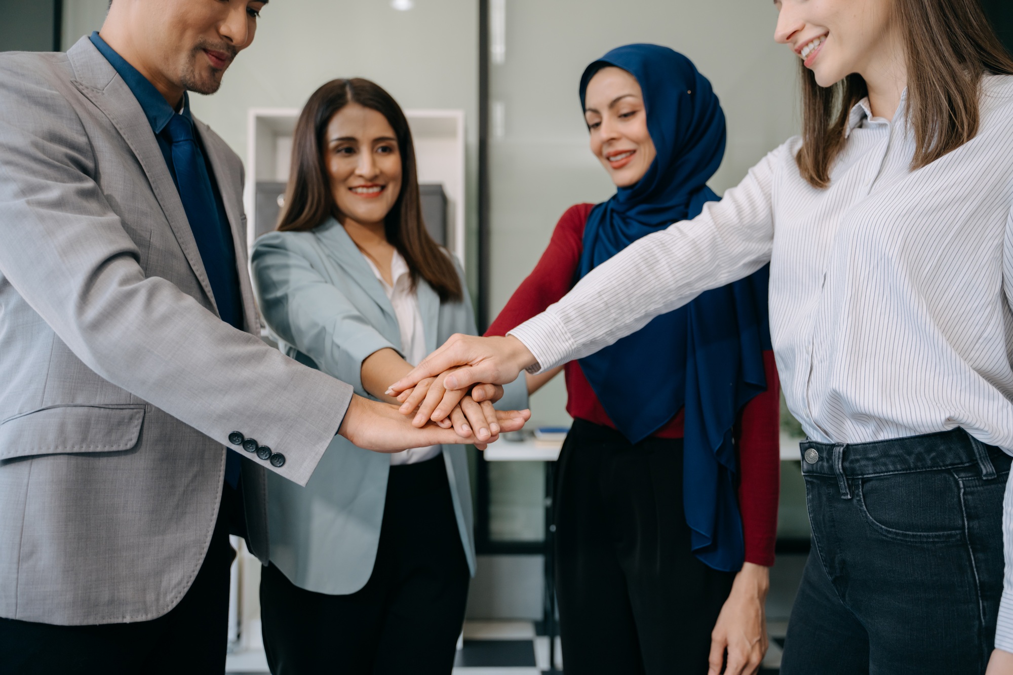 Teamwork business concept of group of three coworkers join hand together during their meeting.