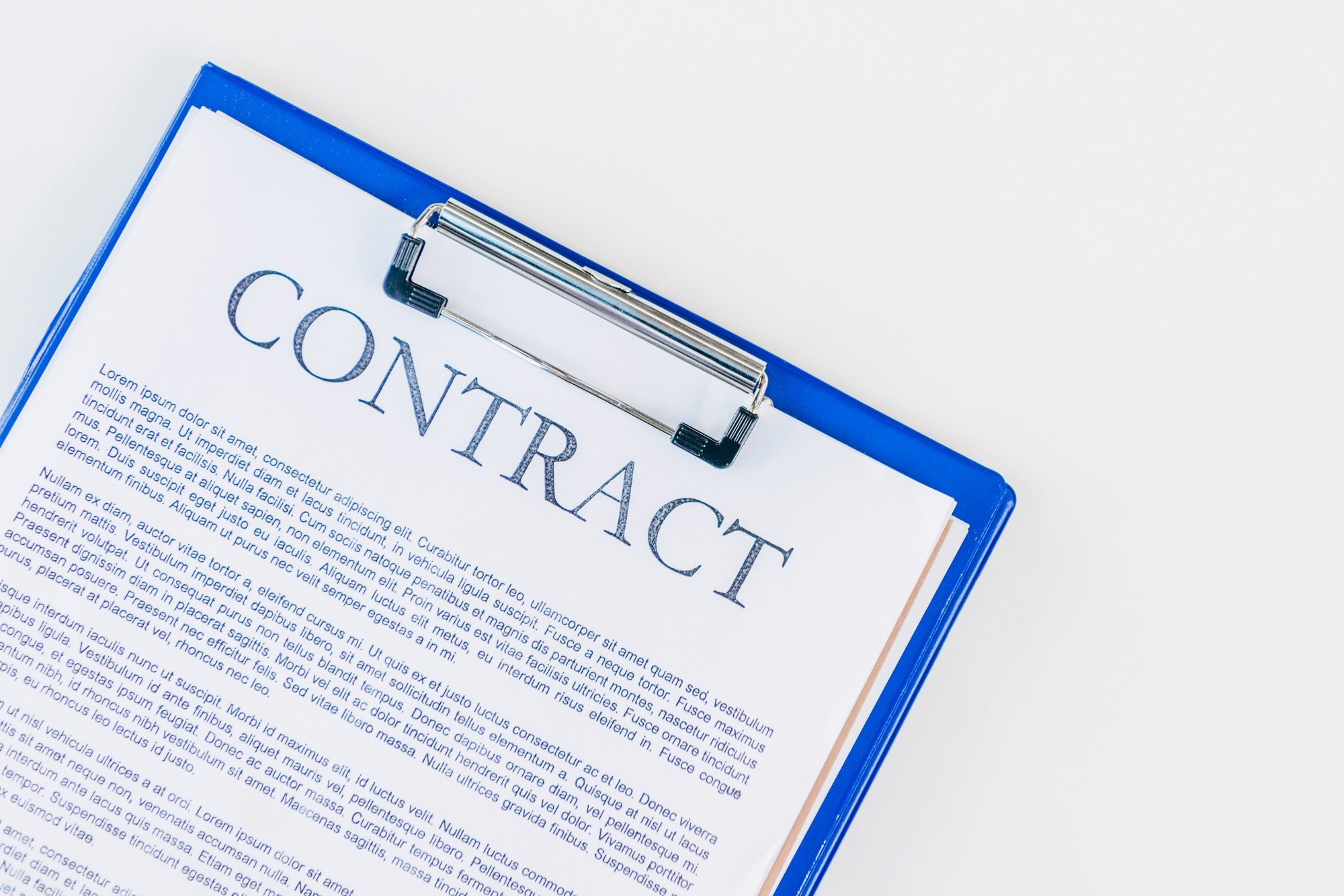 top view of clipboard with contract on white surface