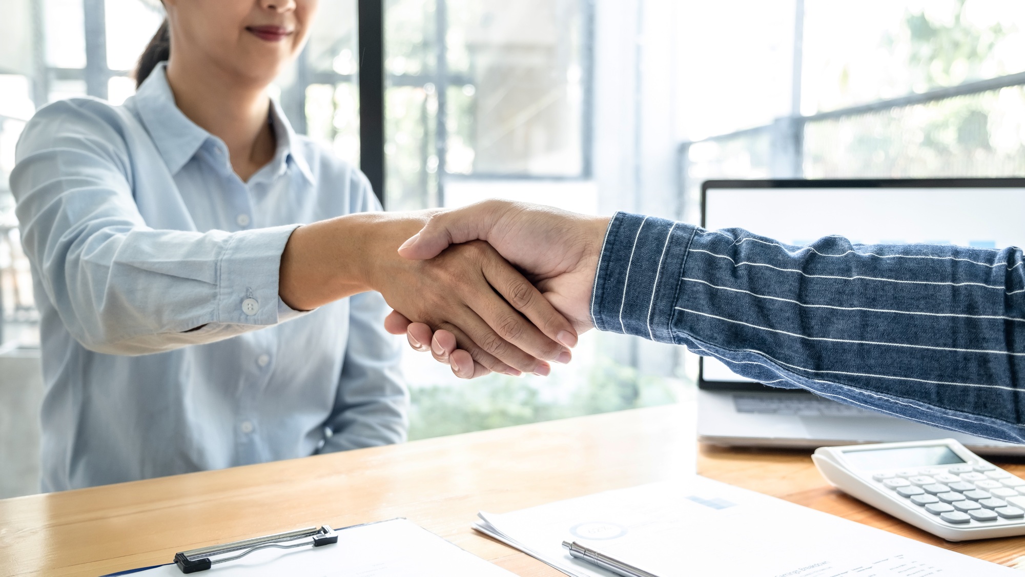 Two business people shaking hands after discussing a good deal of contract agreement