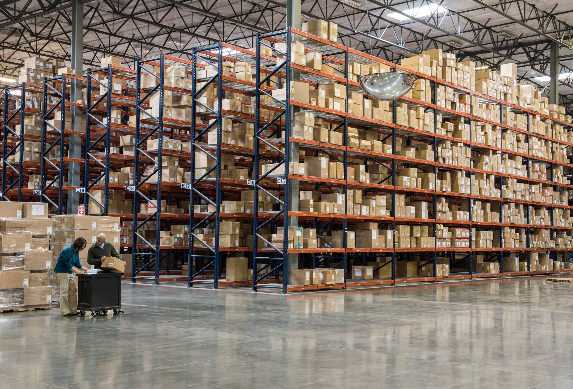 Two employees checking inventory in temporary storage in a distribution warehouse.
