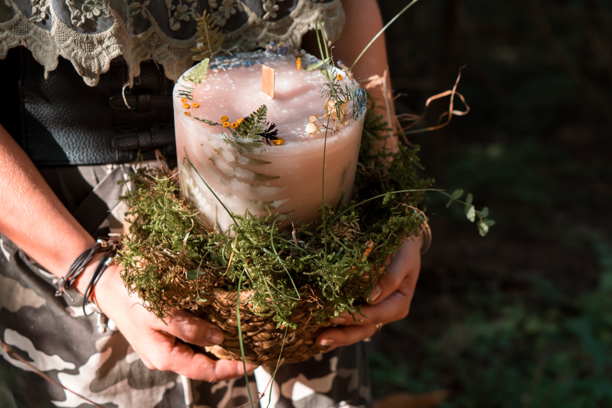 Woman holding in hands Craft homemade candle outdoors