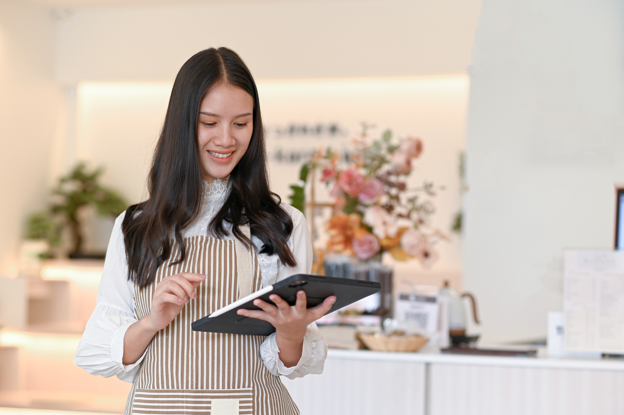 Woman taking customer orders in restaurant.