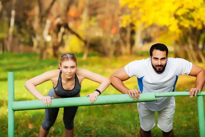 Woman training with personal trainer at park
