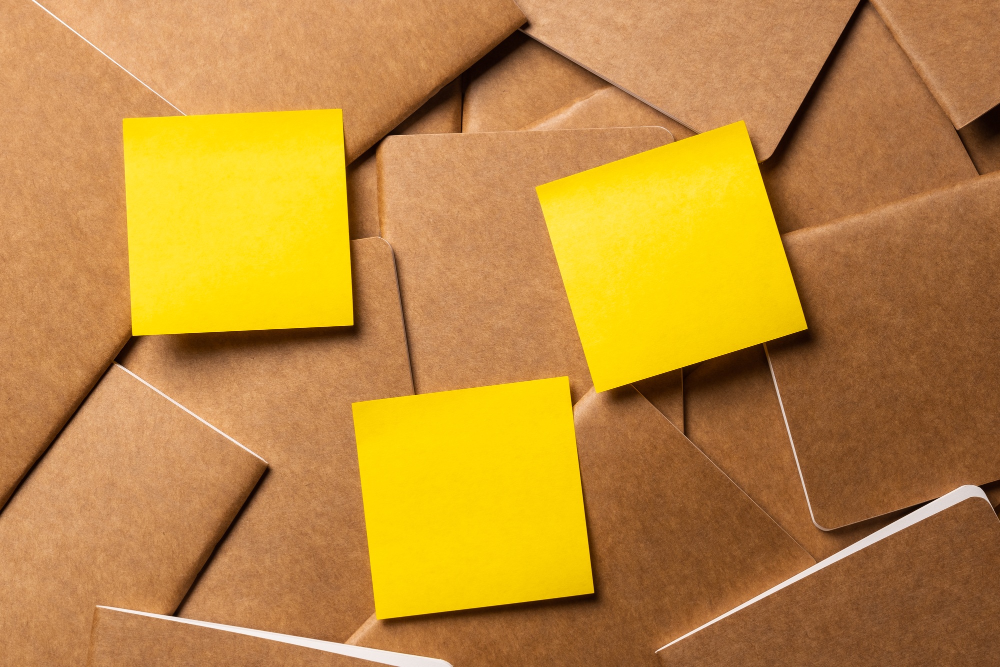 yellow sticky note on kraft brown notebook on table