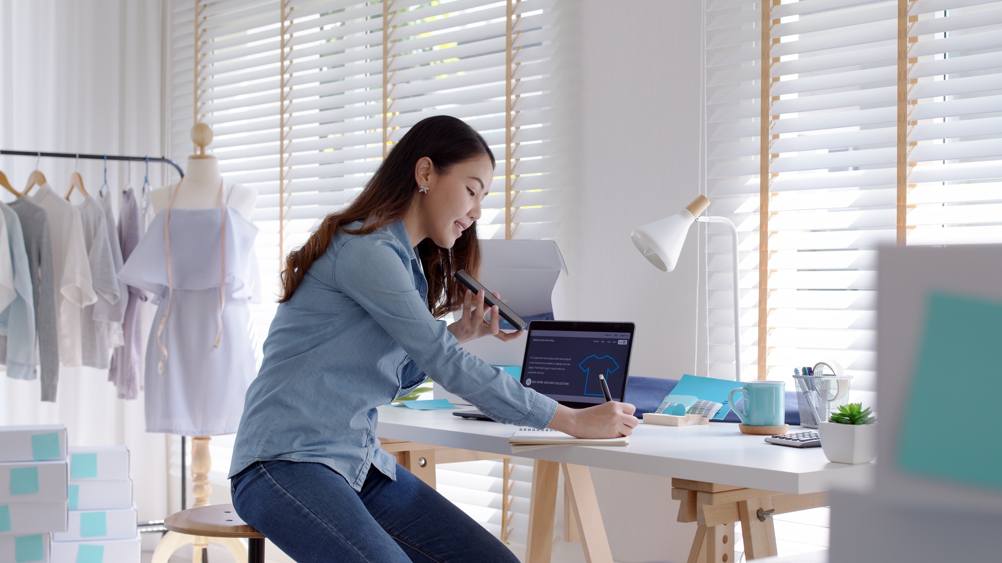 Young asia seller woman happy work on laptop busy cellphone call chat to customer
