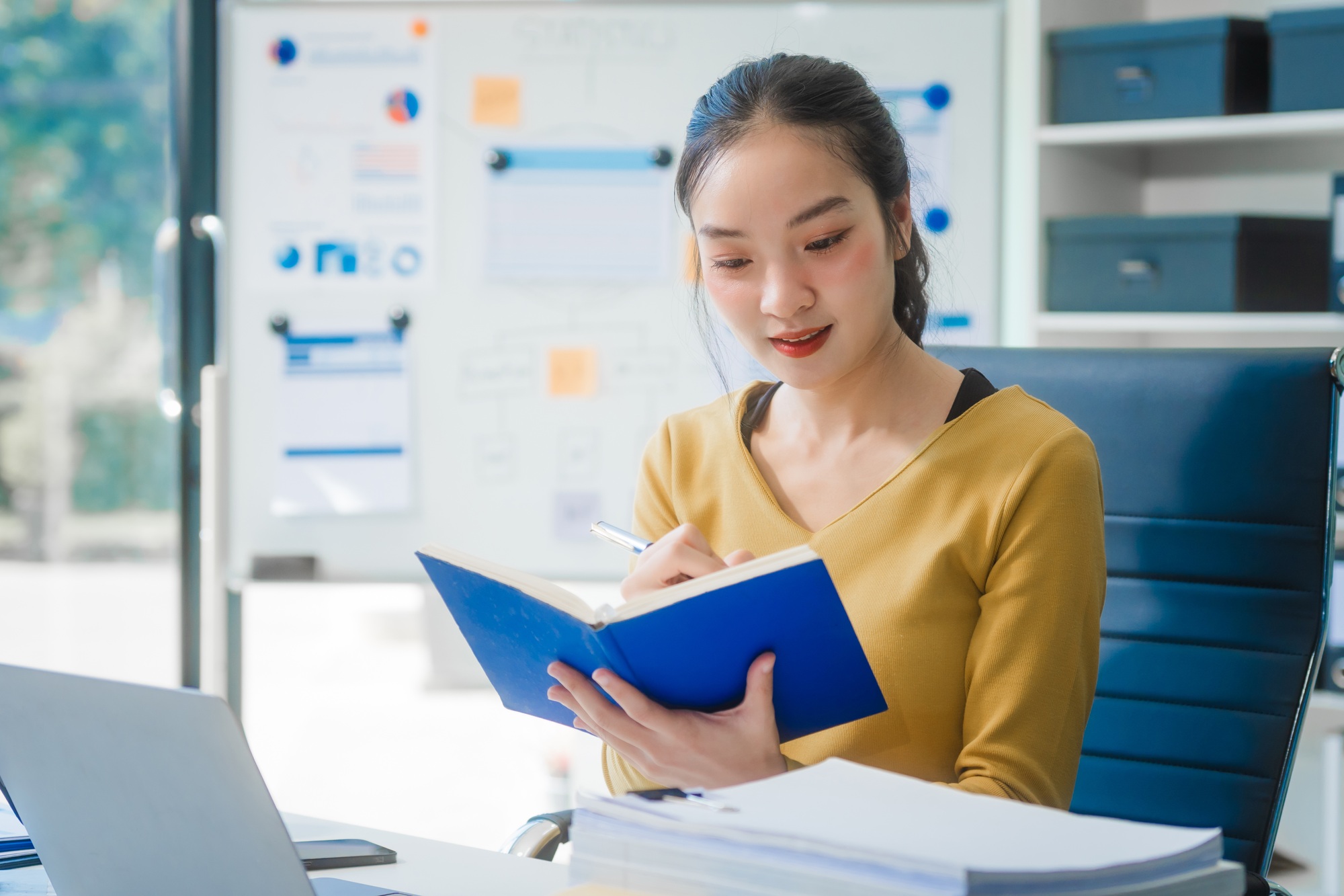 Young Asian businesswoman at desk, managing appointments and analyzing equity financing