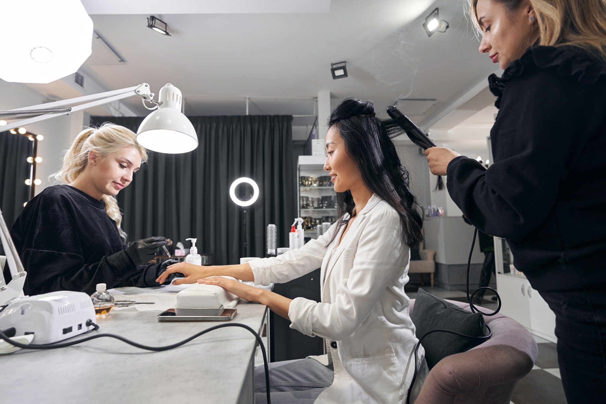 Young attractive female with long hair is getting hairstyling at parlor