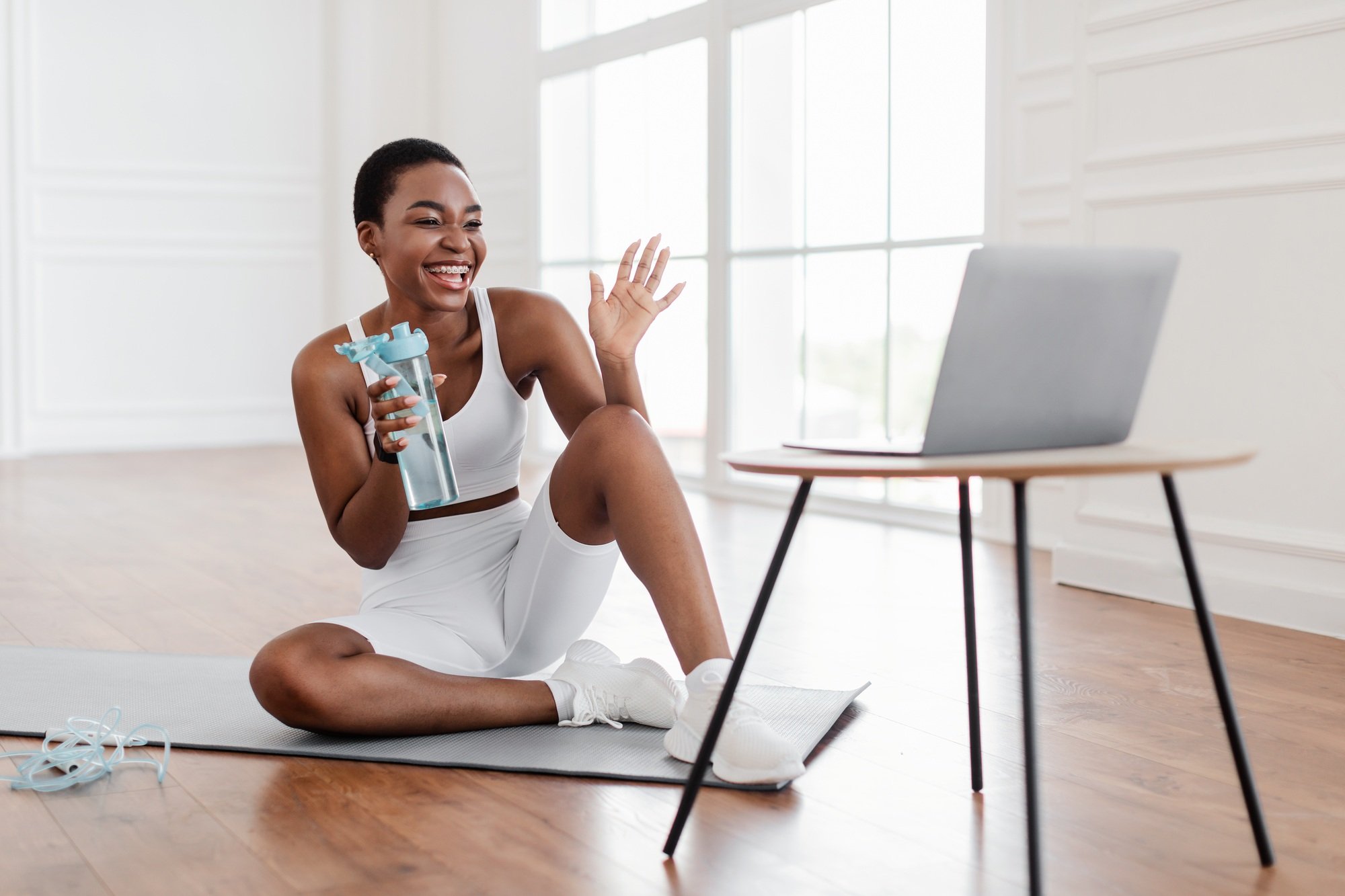 Young black woman woman talking with online coach using pc