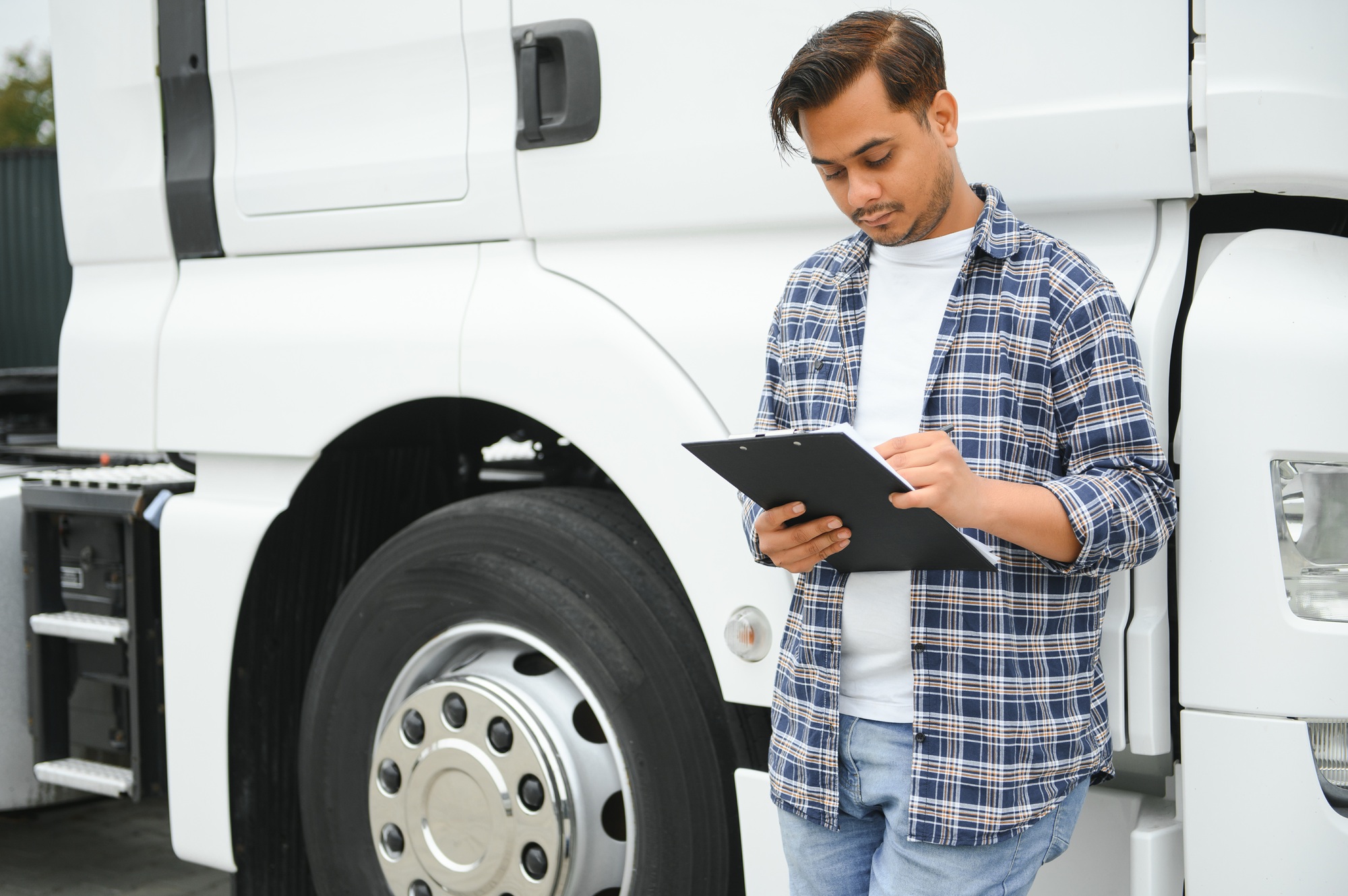 Young indian businessman with his freight forward lorry or truck.