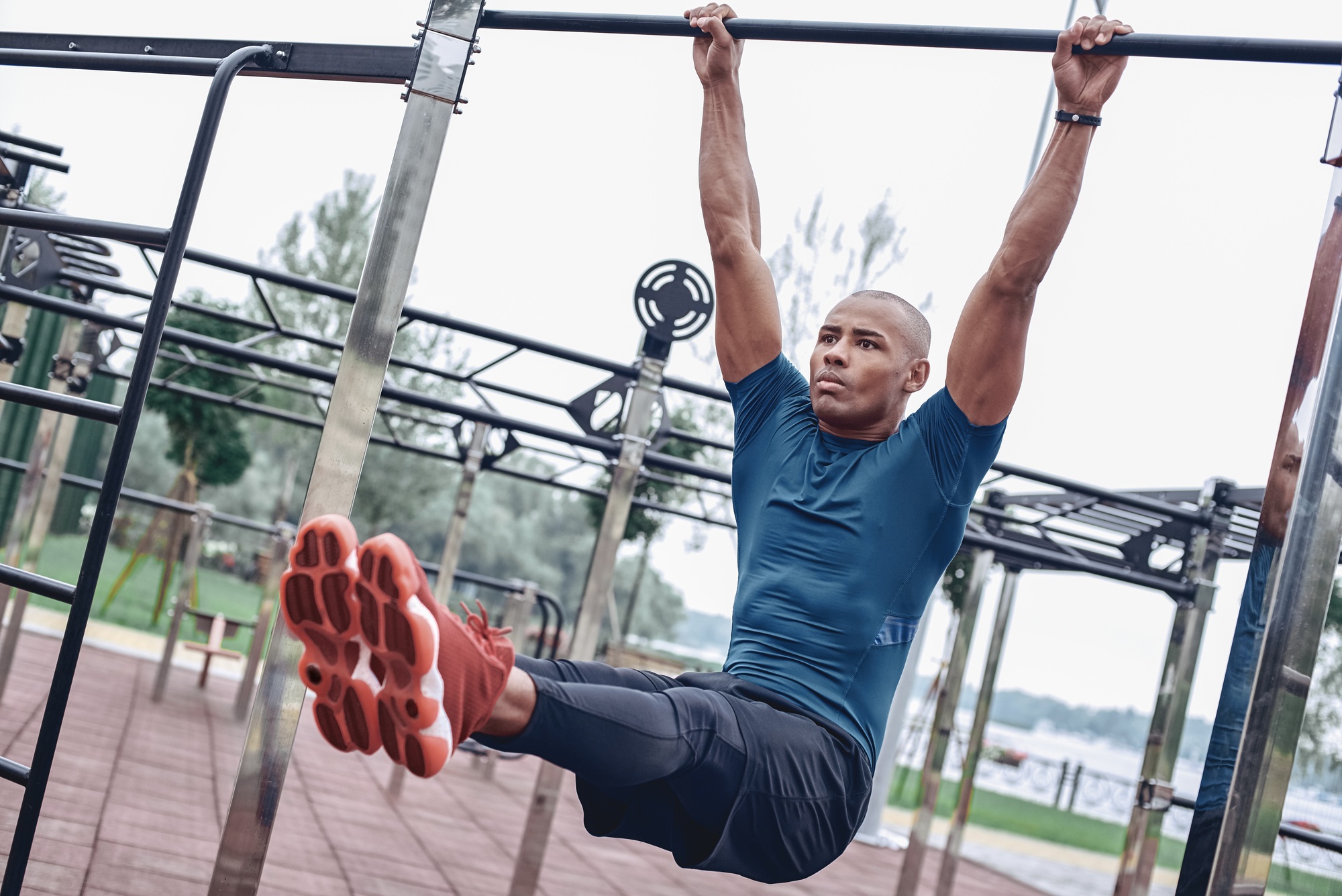 Young male jogger athlete training and doing workout outdoors in