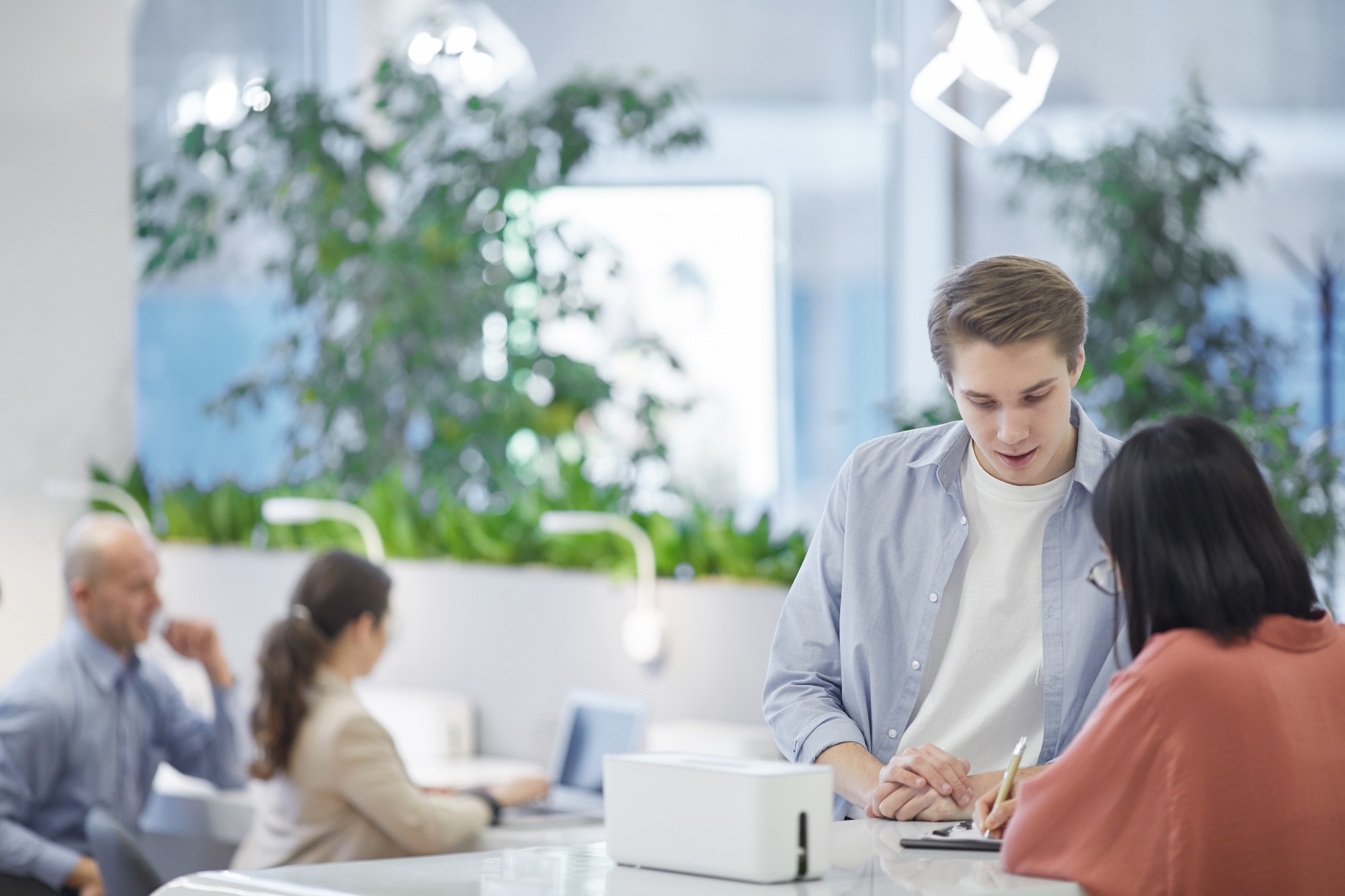 Young Man talking to Receptionist at Company