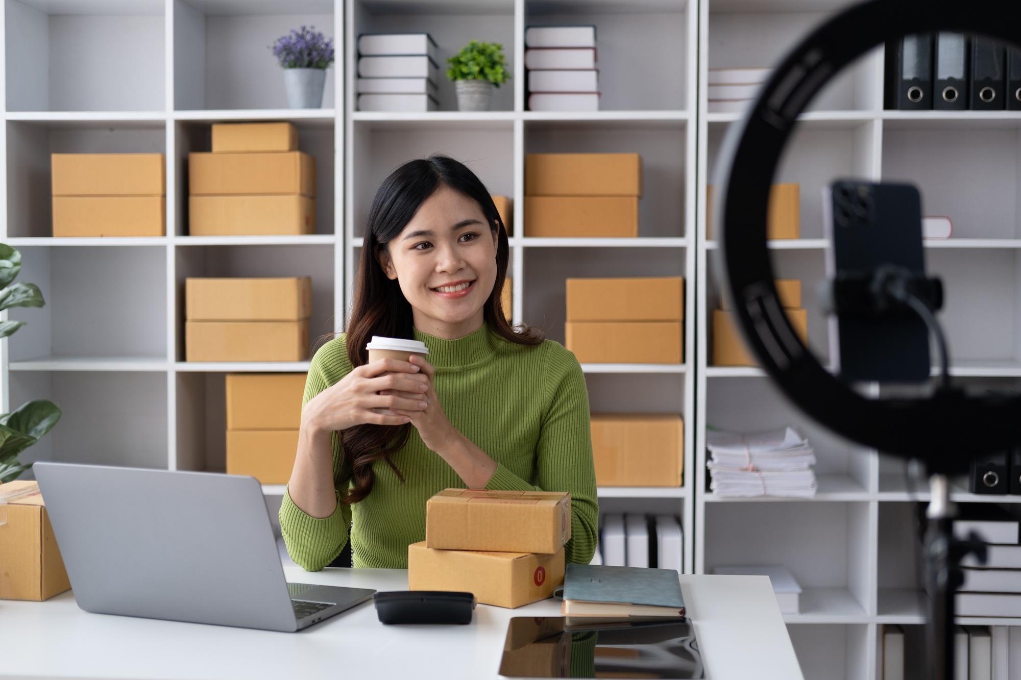 Young online shopping shop owner livestreaming and interacting with her customer.