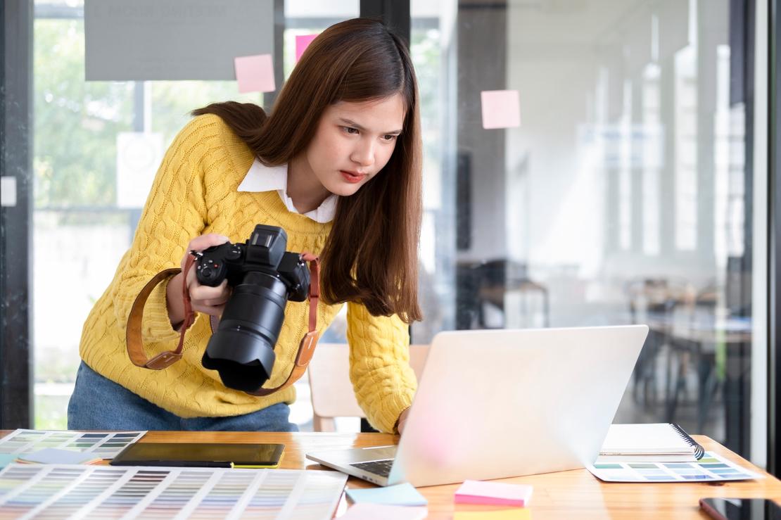 Young photographer checking images from digital camera.