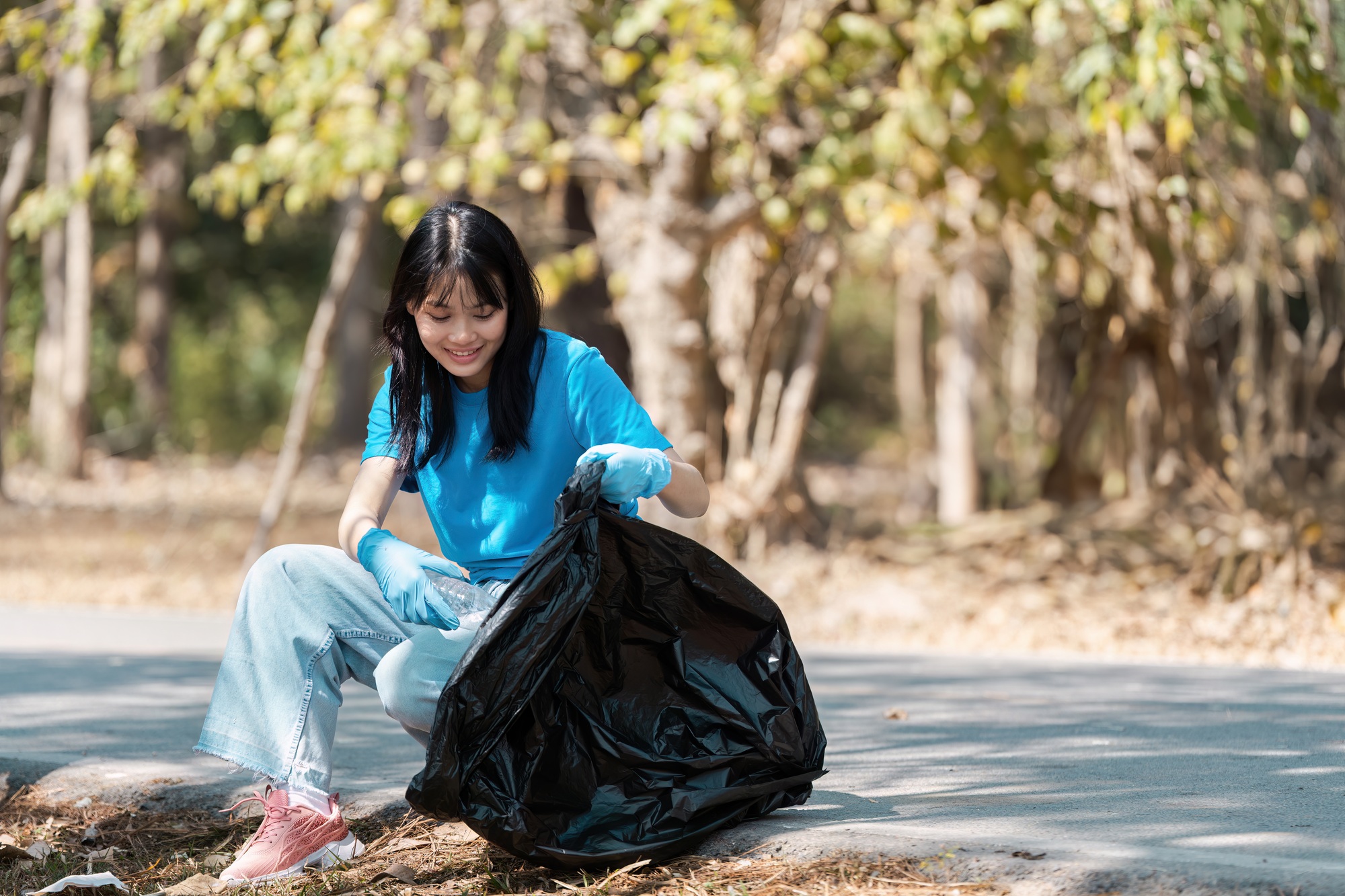 Young Volunteer Collecting Trash in Park, Environmental Conservation and Community Service Concept