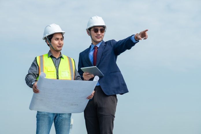 A business owner and technician plan to install solar panels on the roof that generates