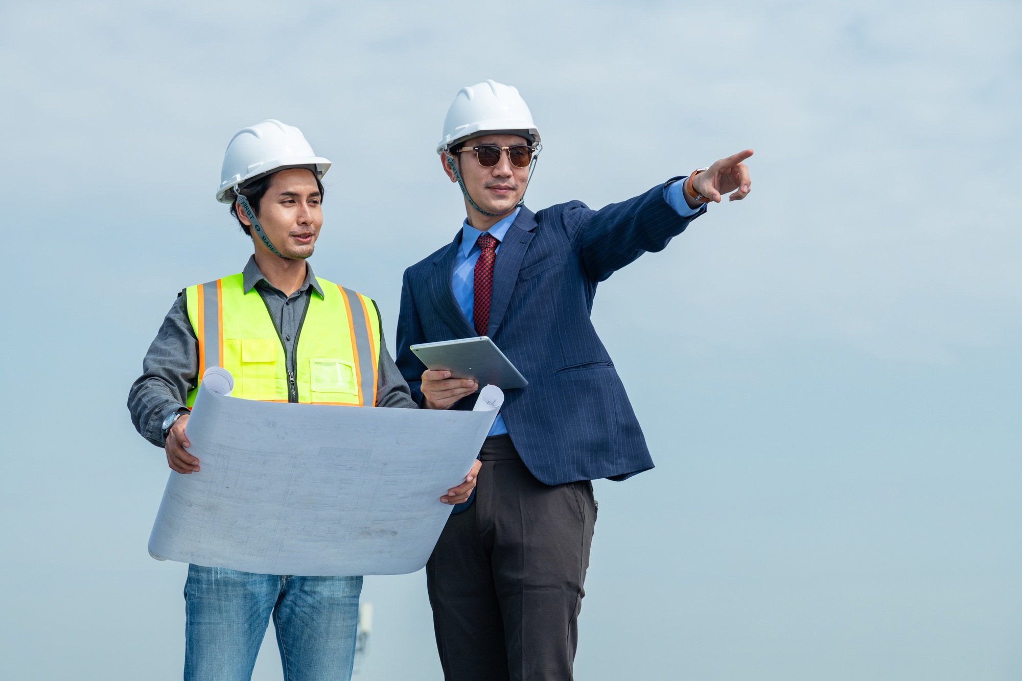 A business owner and technician plan to install solar panels on the roof that generates