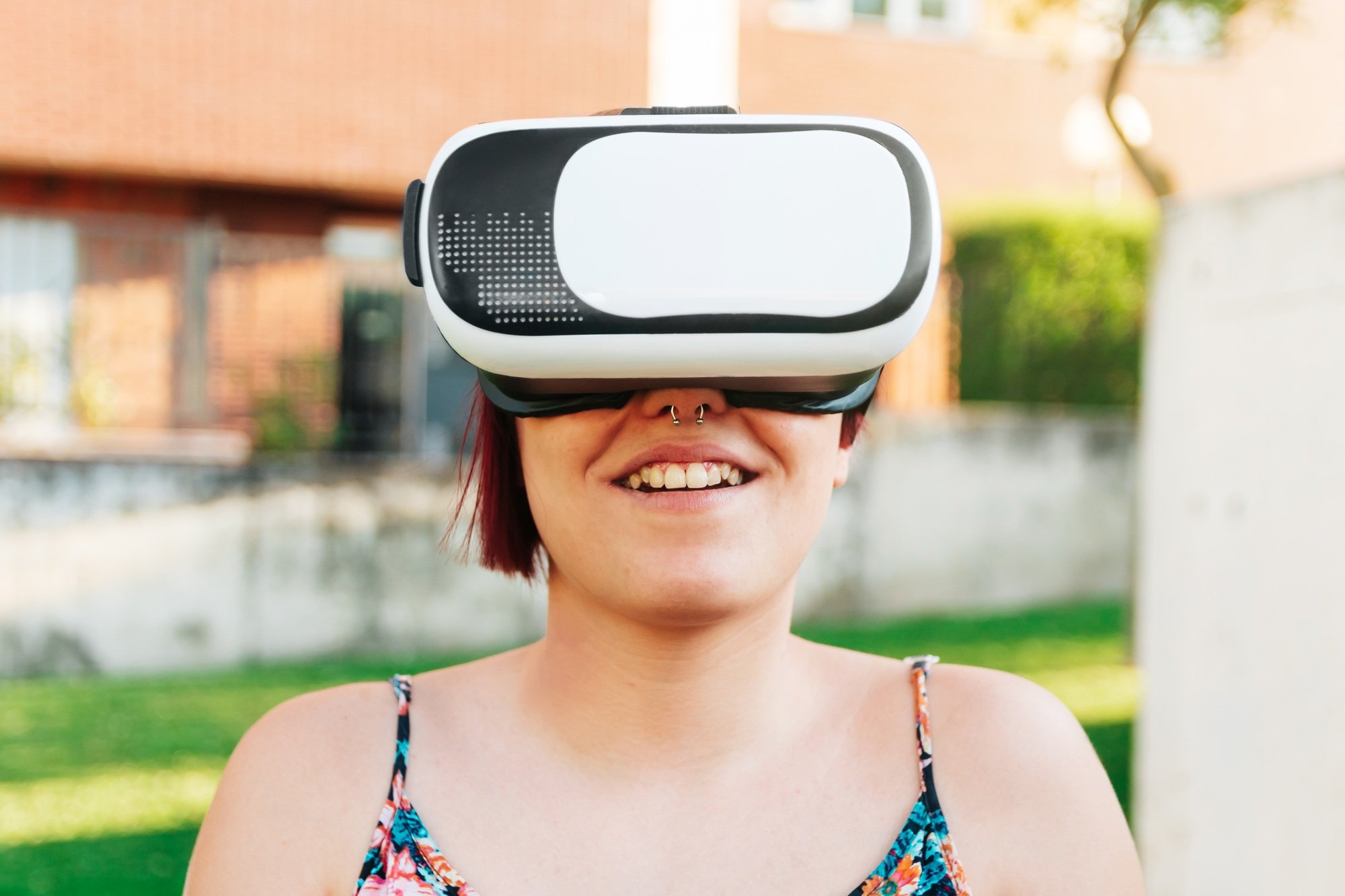 Amazed young woman experiencing virtual reality in VR headset outdoors