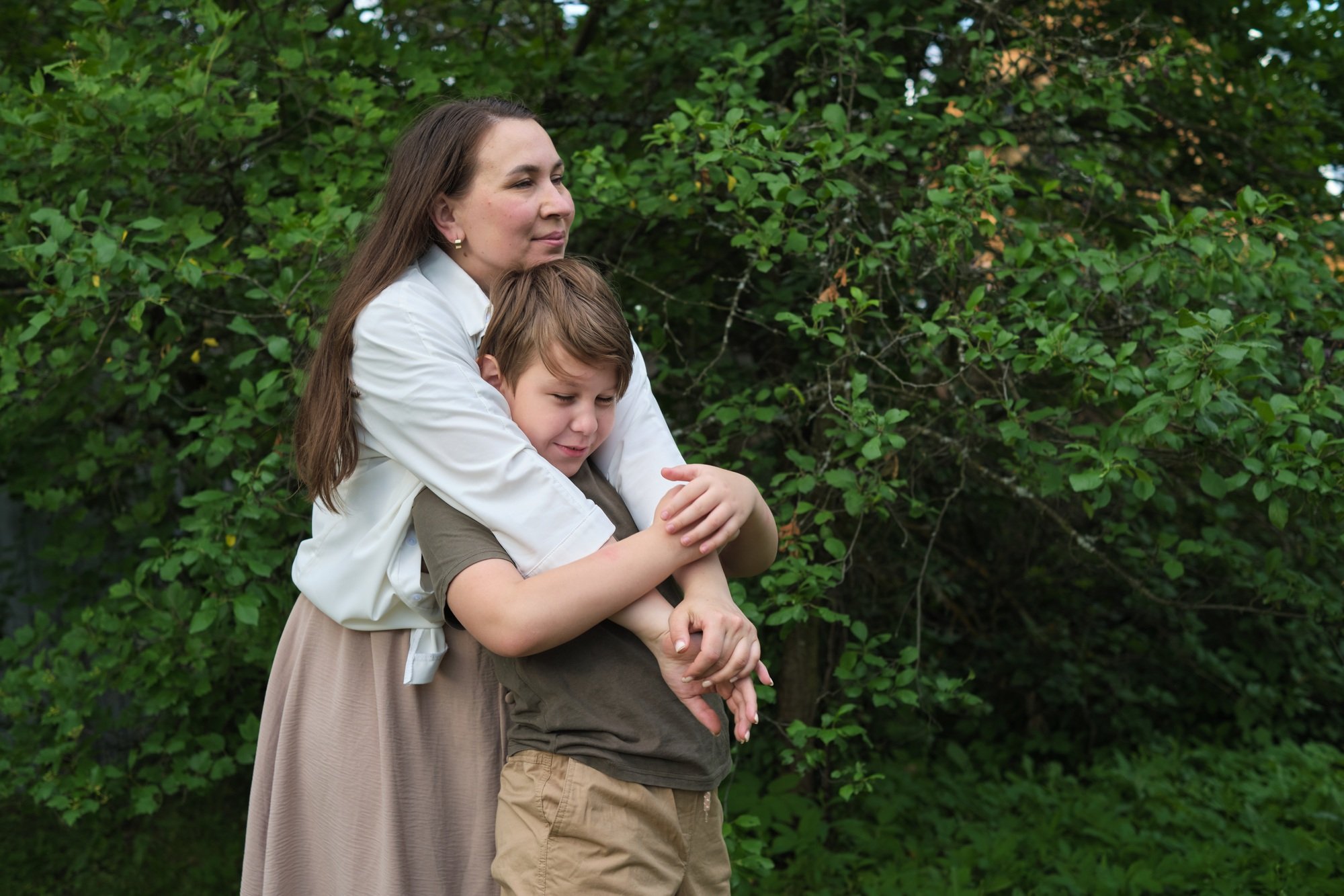 An authentic image of a mother and her pre-teen son in a garden, reflecting the values of childhood
