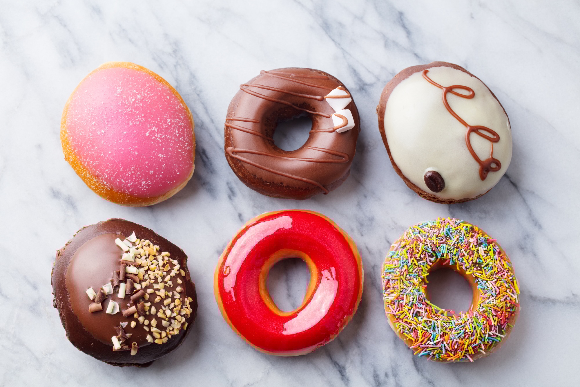 Assortment of Donuts on Marble Table Background. Top view.