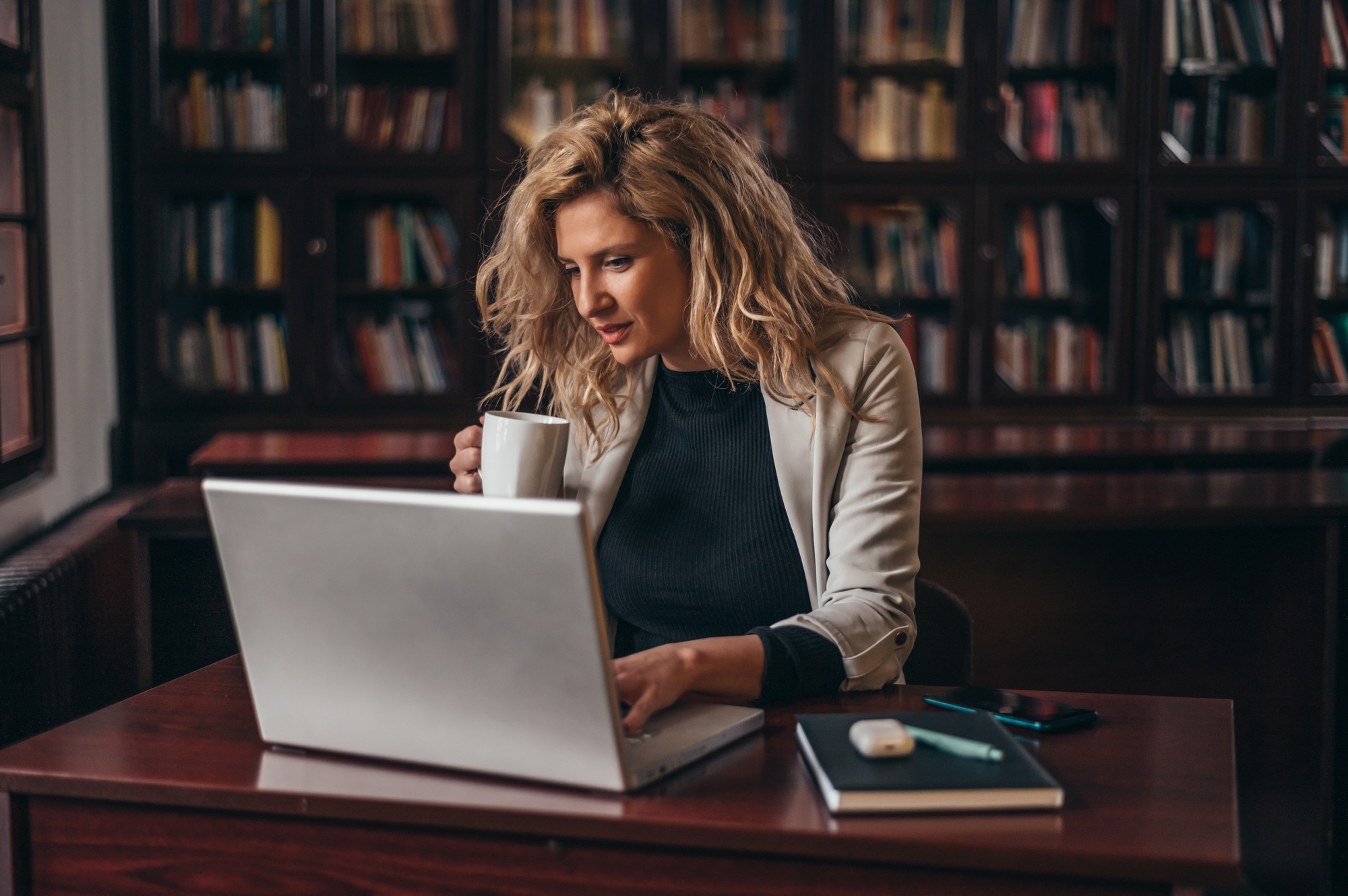 Businesswoman using a laptop and a business planner in an office