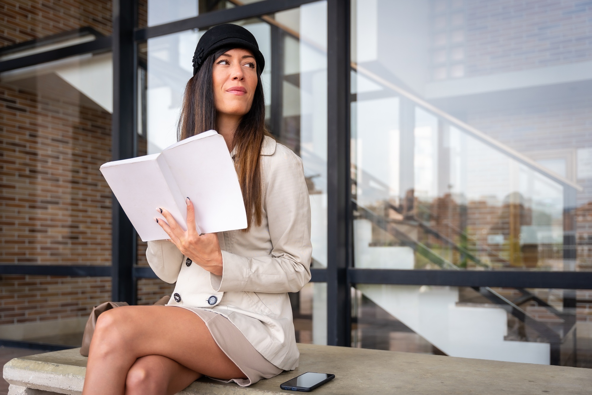 Businesswoman writing in work planner sitting in the city, copy space