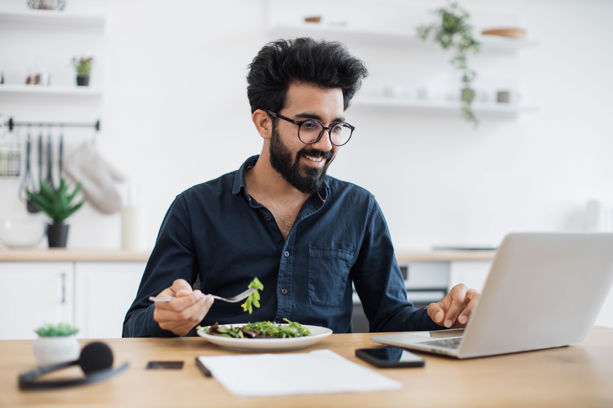 Employee eating salad during lunch break in home office