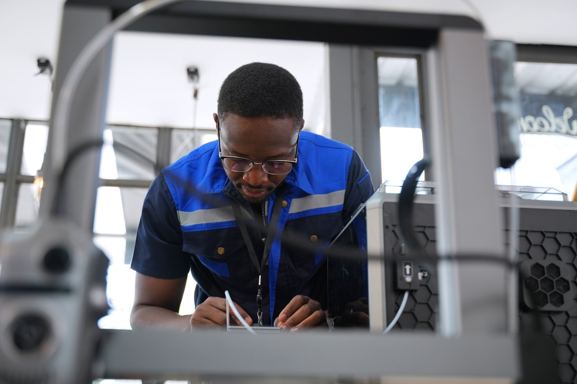 Engineer is working at 3D printing workshop.
