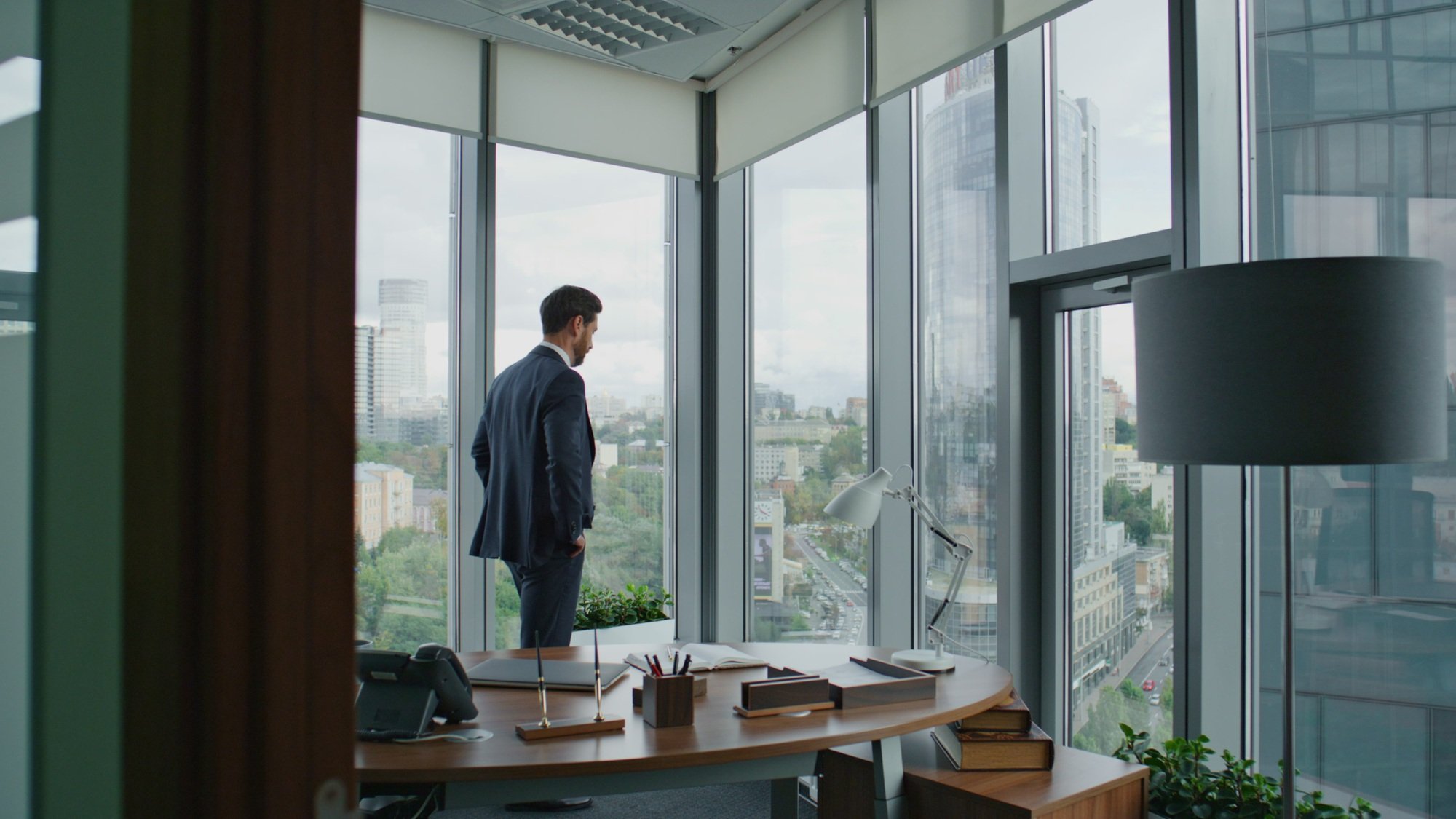 Entrepreneur looking office window. Smart businessman thinking business ideas.