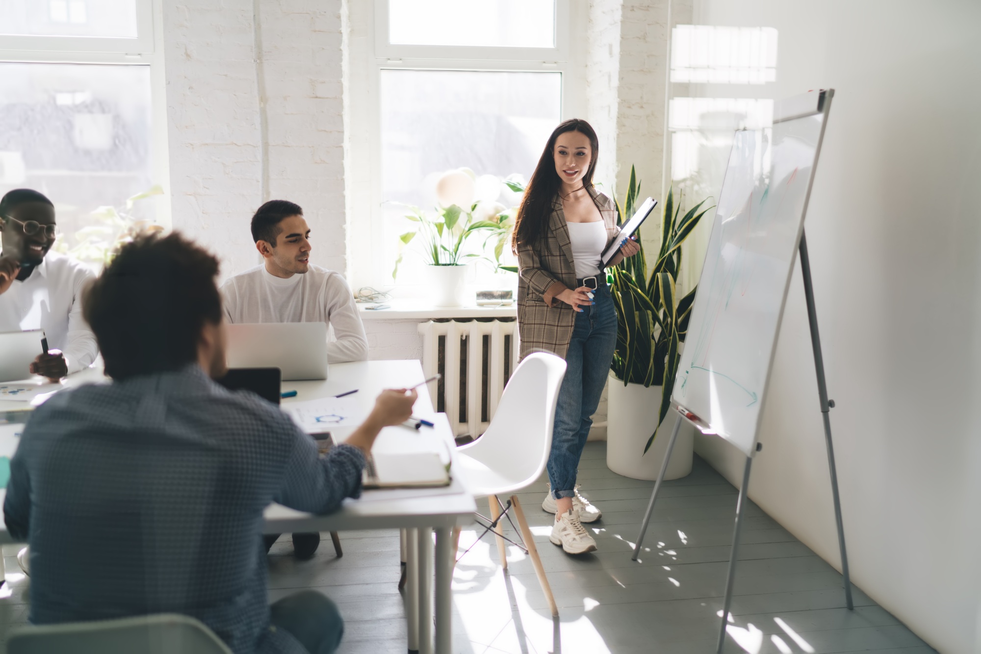 Female employee explaining business solution to diverse colleagues